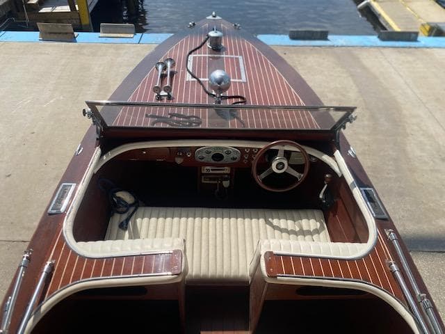 Grand Craft Classic Runabout 2000 with wooden deck and vintage steering, docked by the water.