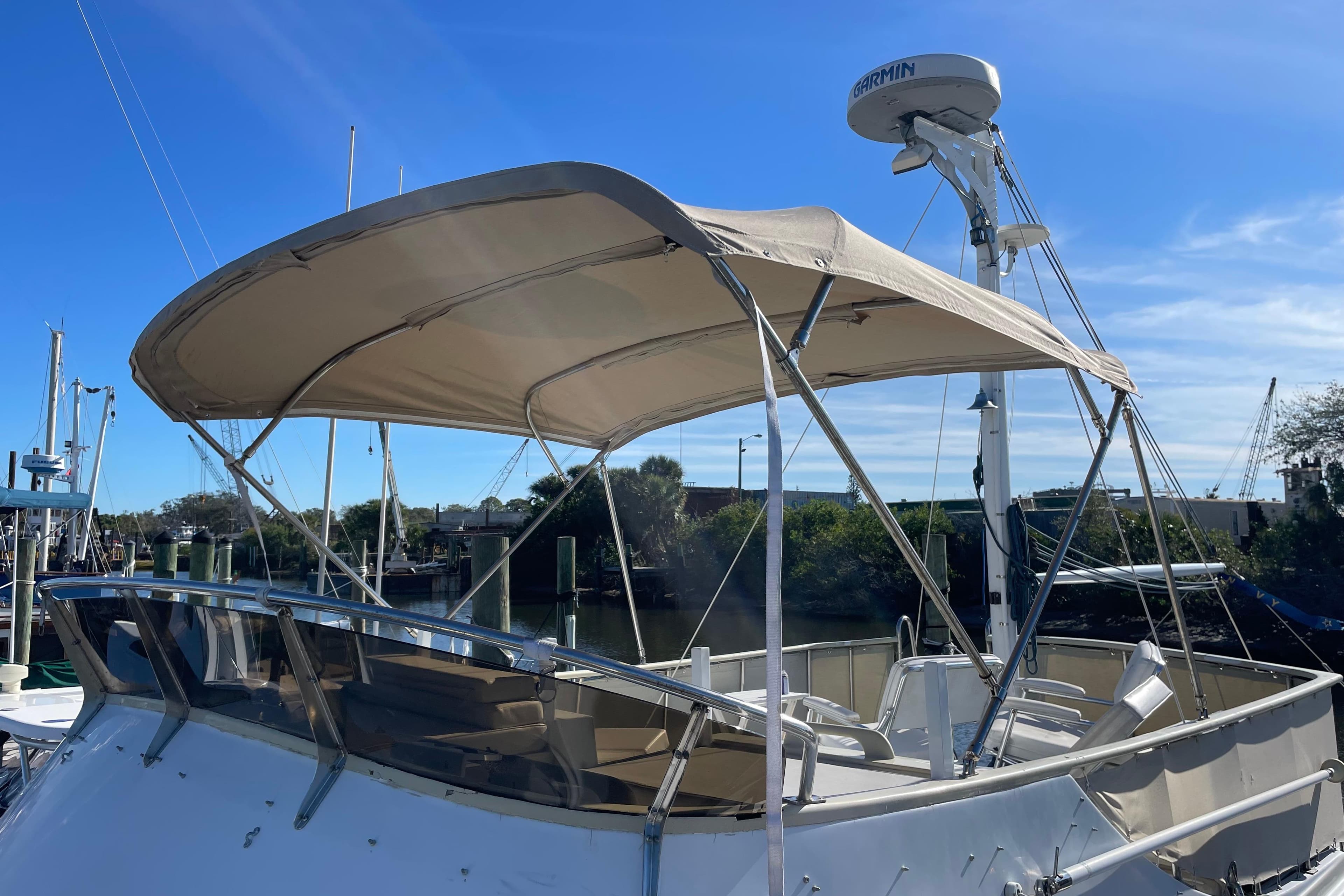 1987 Albin 36 Trawler with canopy, docked under clear blue sky.