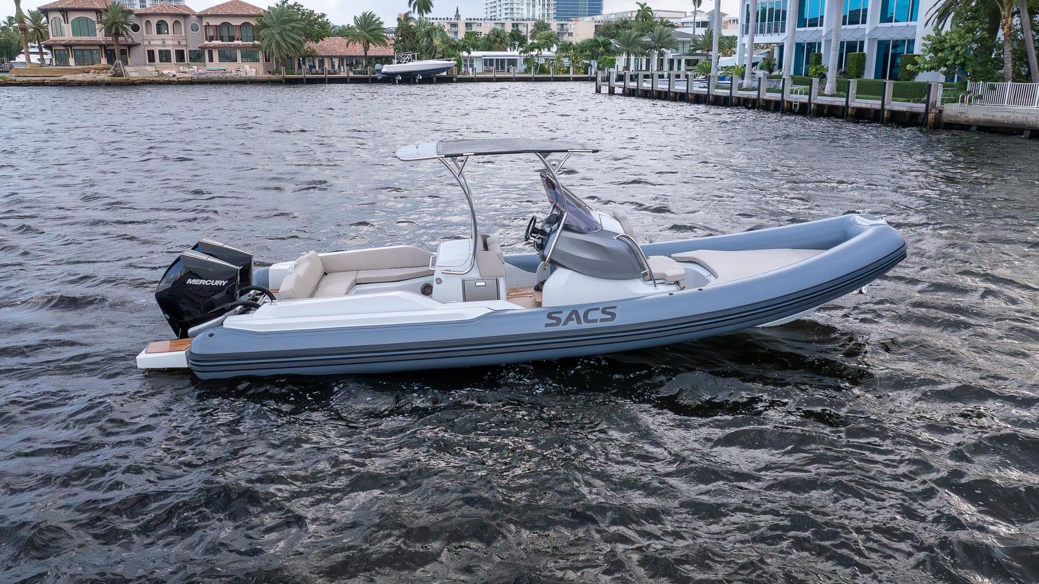 2024 SACS Strider 900 boat on calm water near villas.