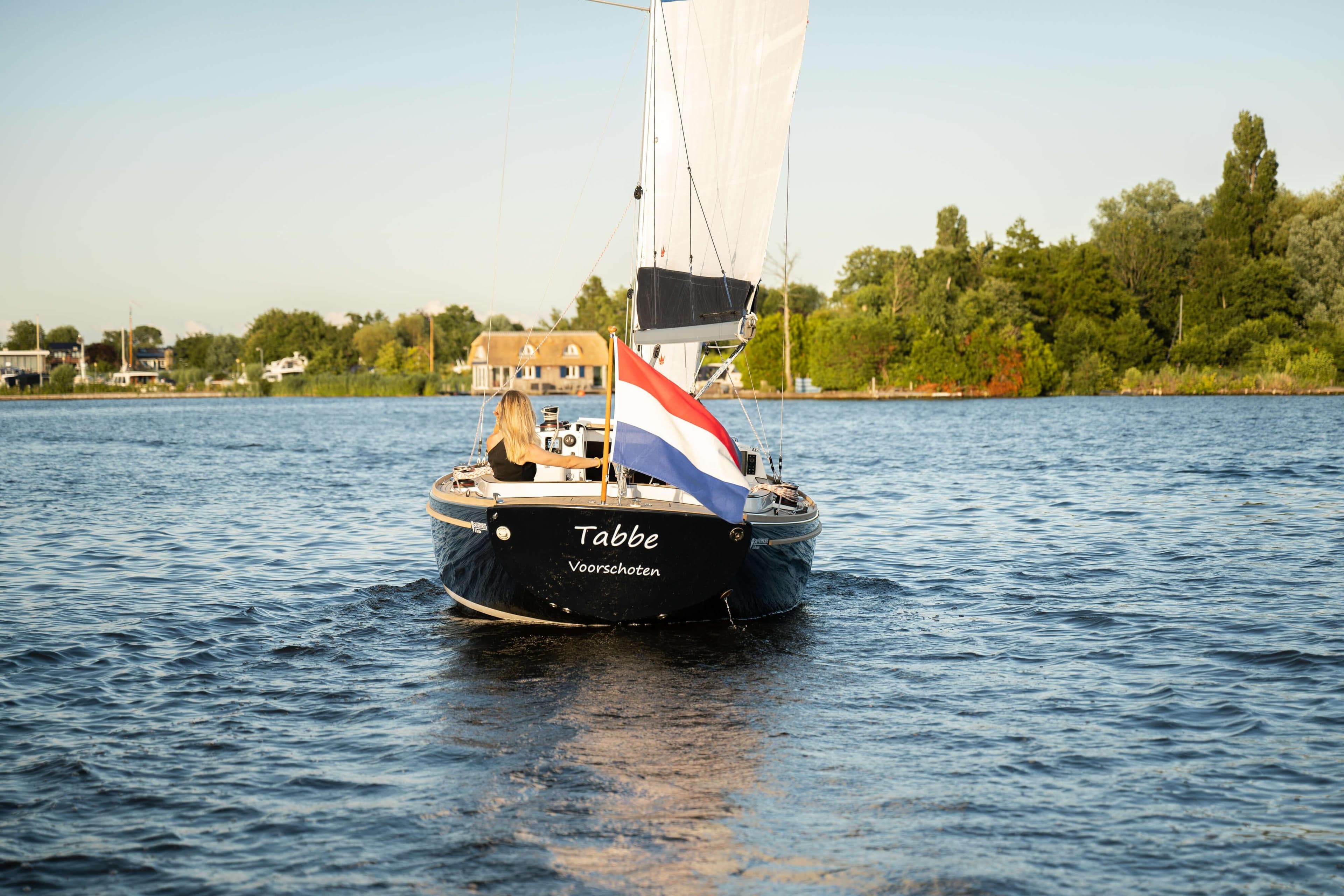 Saffier SC 8M Cabin 2026 sailing on a serene lake with a Dutch flag.