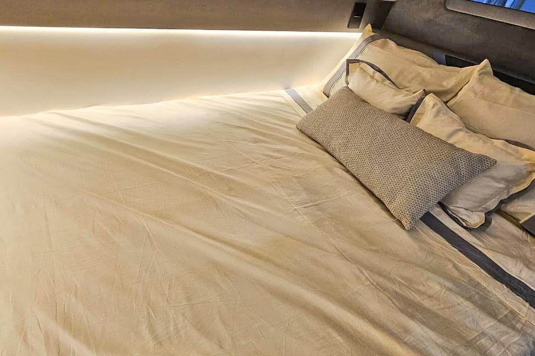 Luxurious bed with elegant pillows and soft lighting in a Hanover 327, 2027 model.