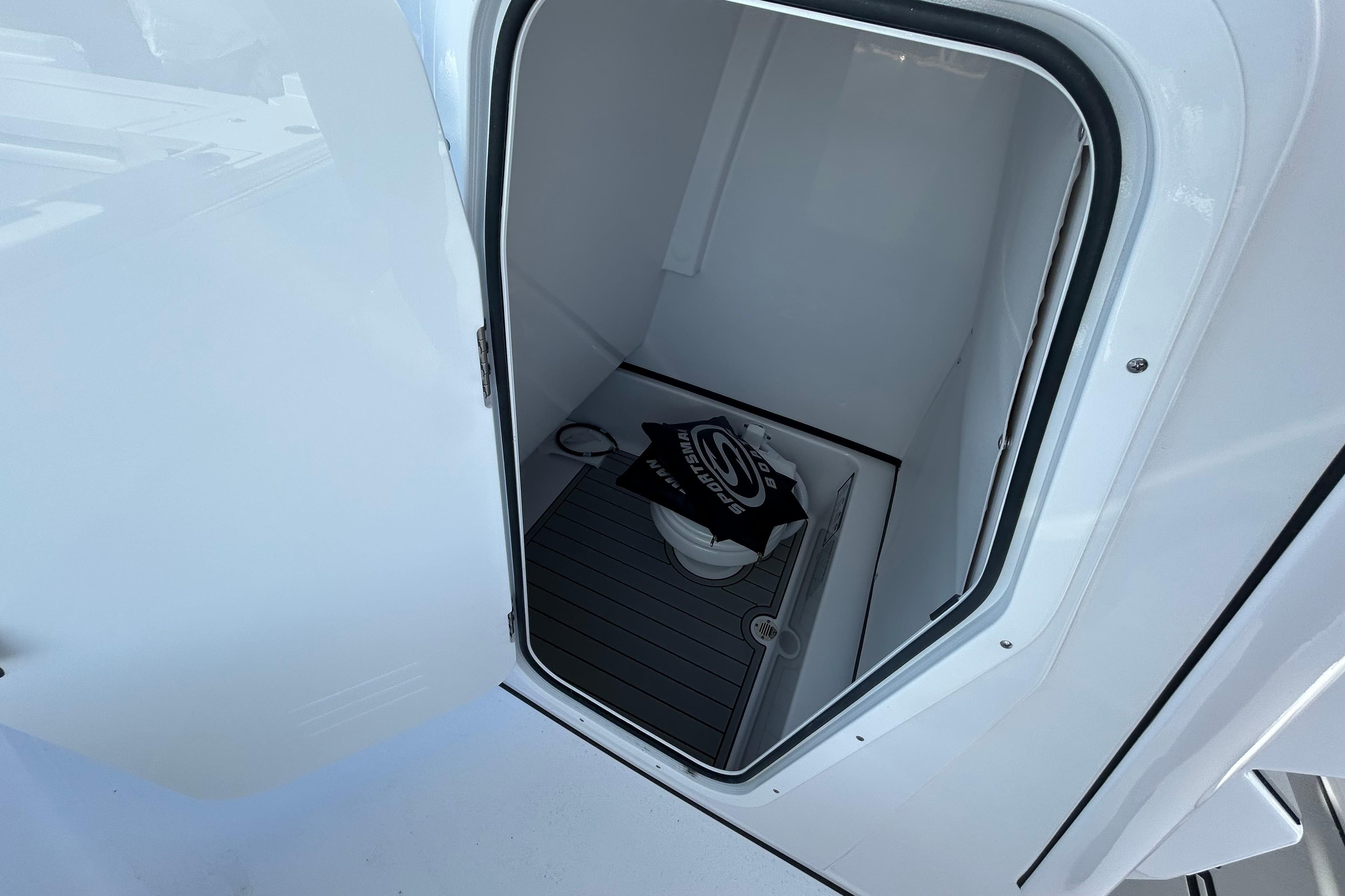 2026 Sportsman Masters 267OE Bay Boat interior storage compartment with open door.