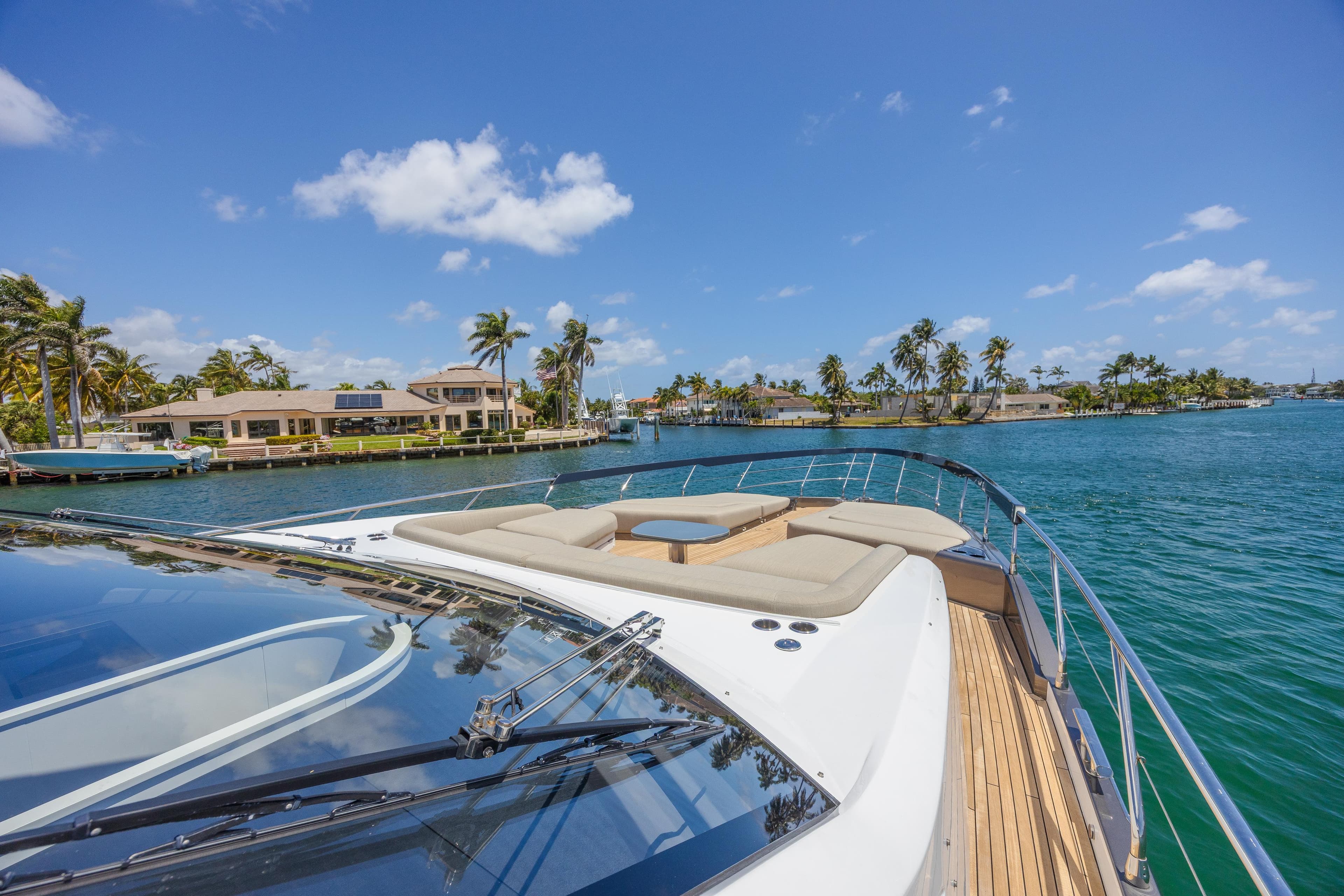 2023 Azimut S8 yacht cruising on a sunny day with palm trees in the background.