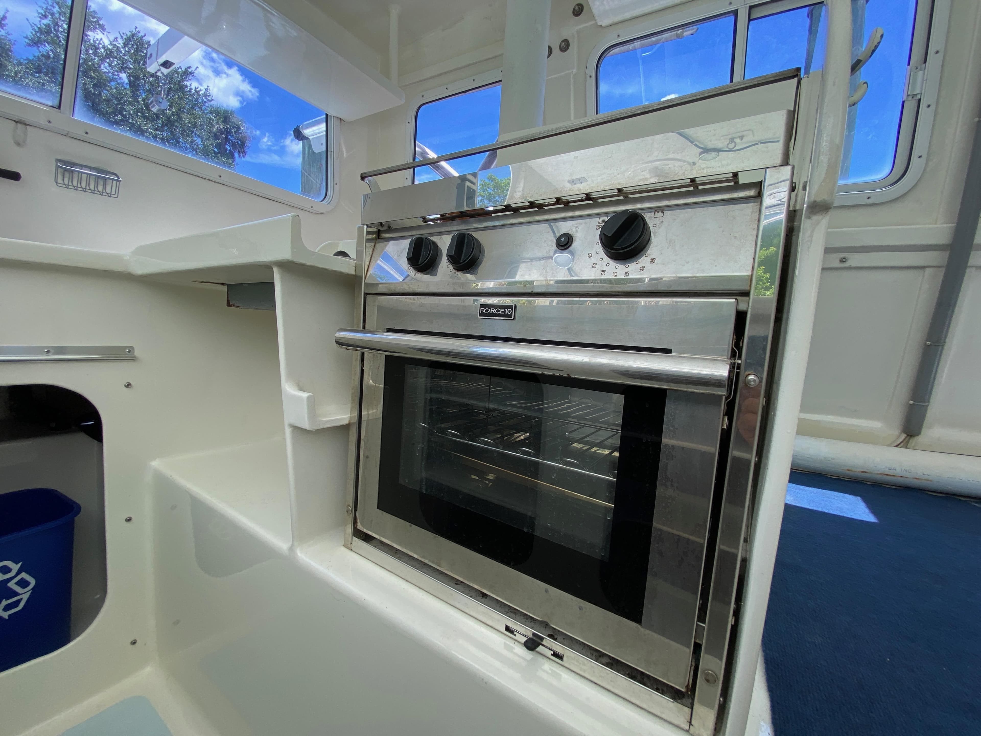 Stainless steel oven in a boat's compact kitchen, Custom 62 model, 1996.