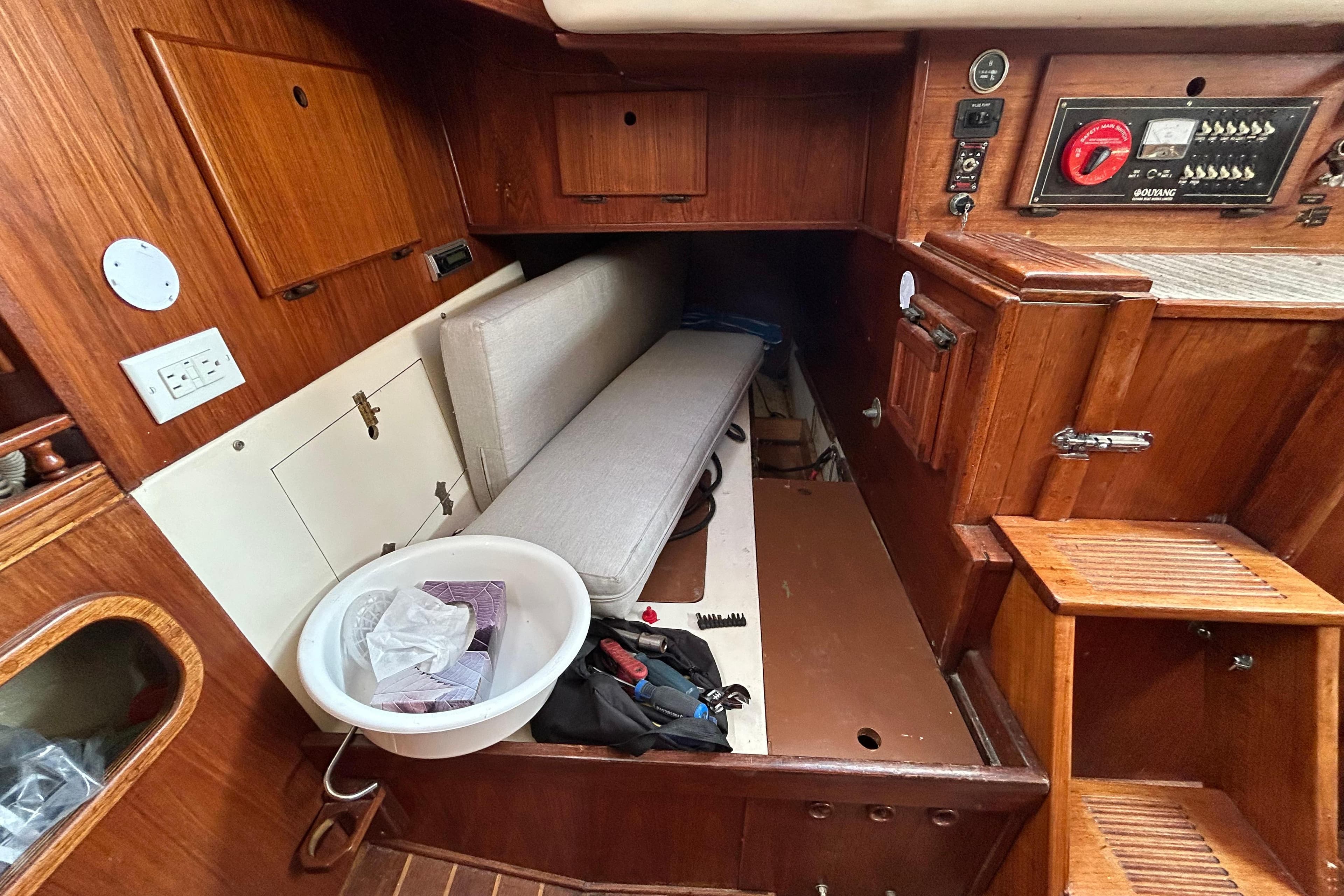 1979 Aloha 34 sailboat interior with wooden cabinetry and cushioned seating area.