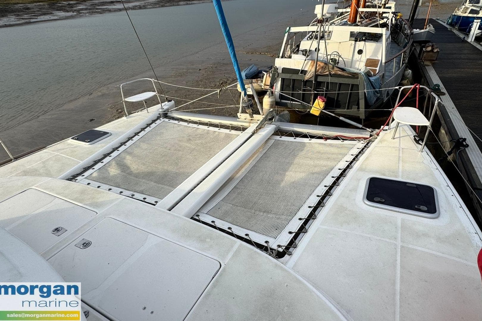 2004 Lagoon 380 Catamaran Series 1 docked, featuring spacious deck and netting.