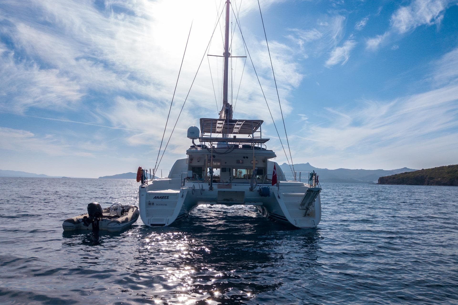 2005 Lagoon 440 catamaran on serene ocean with clear blue sky.