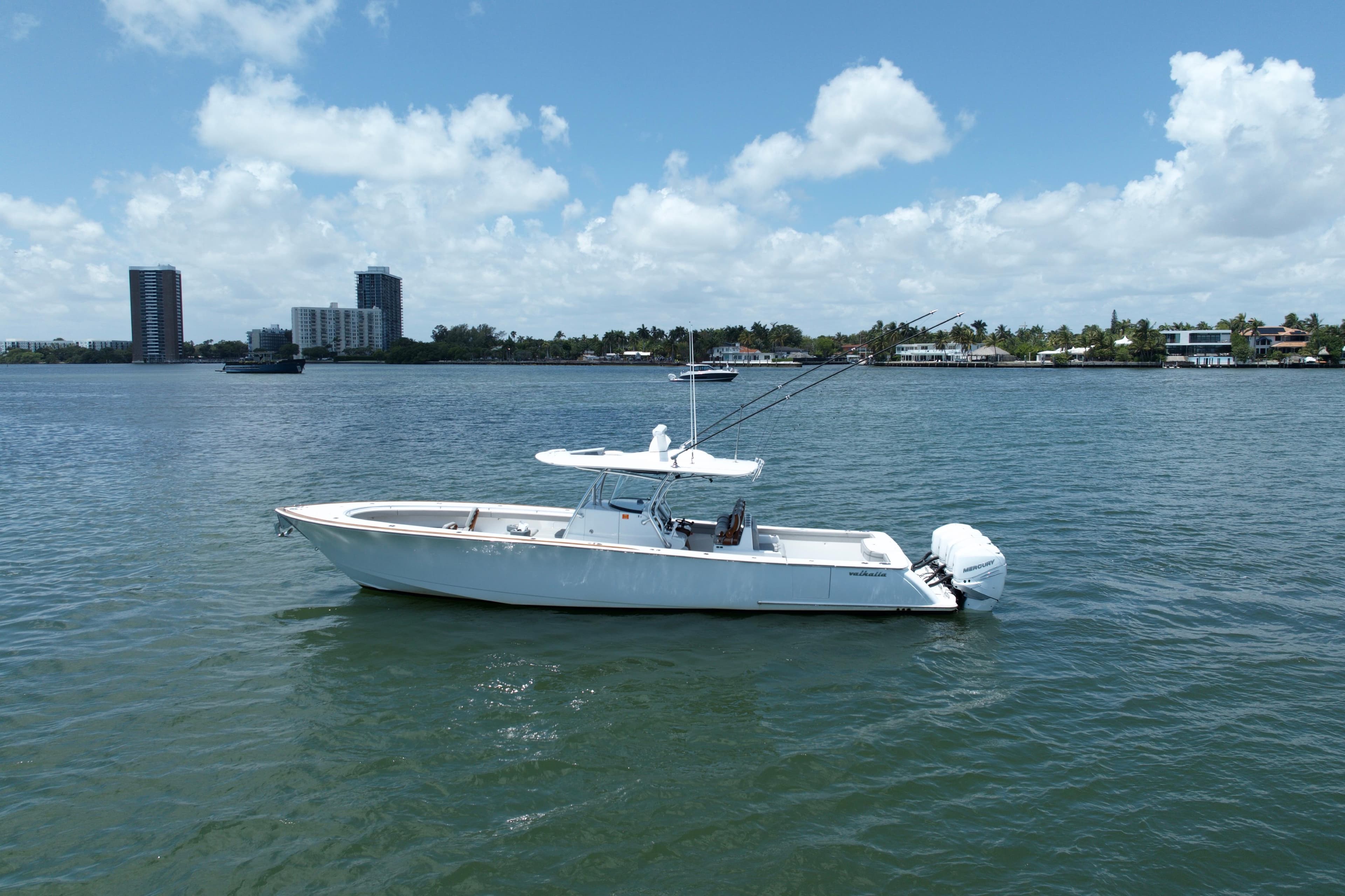 2022 Valhalla Boatworks V-41 on calm water, city skyline in background.