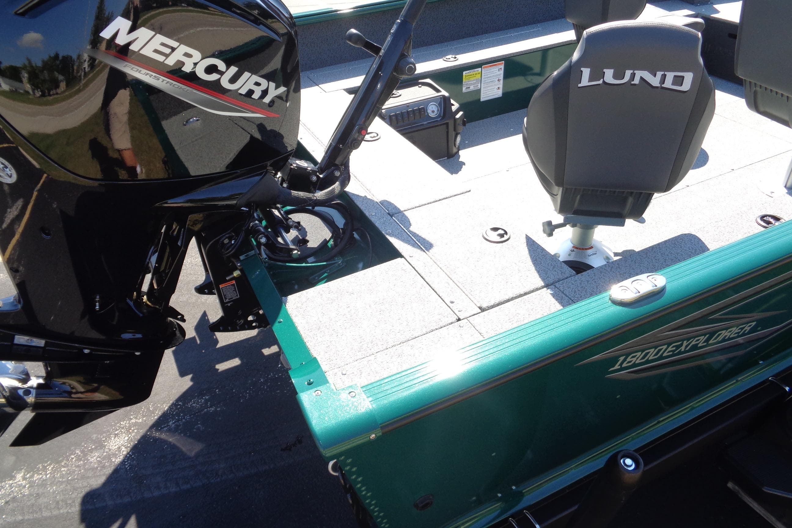 2026 Lund 1800 Explorer Tiller boat with Mercury engine, featuring comfortable seating and sleek design.