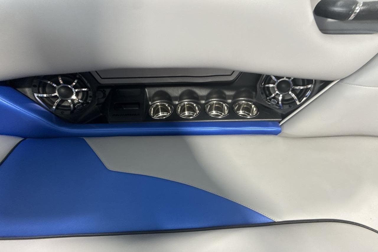 2023 Moomba Mojo interior with blue and gray upholstery, speakers, and cup holders.