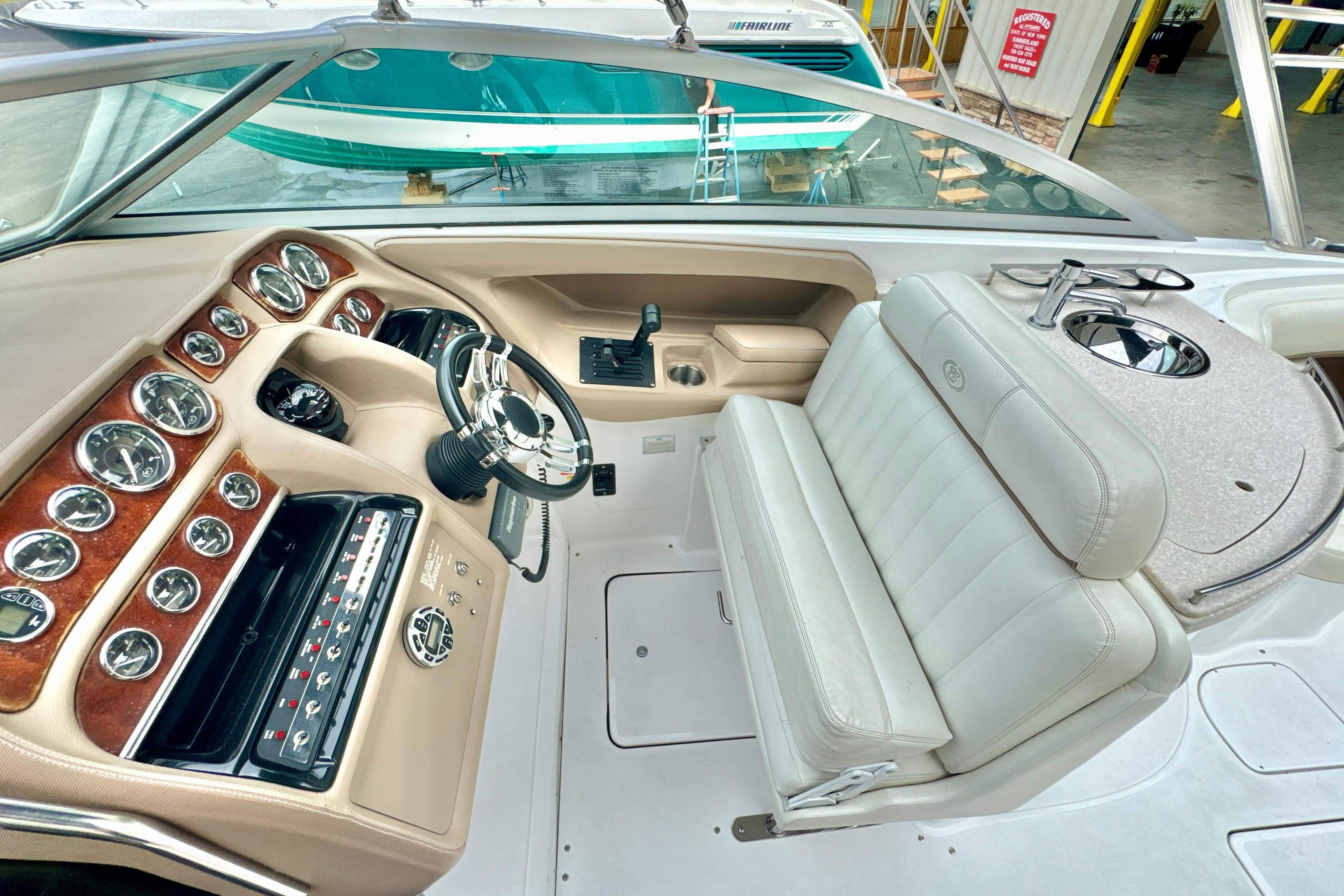2008 Cobalt 323 boat interior with steering wheel, dashboard, and white leather seating.