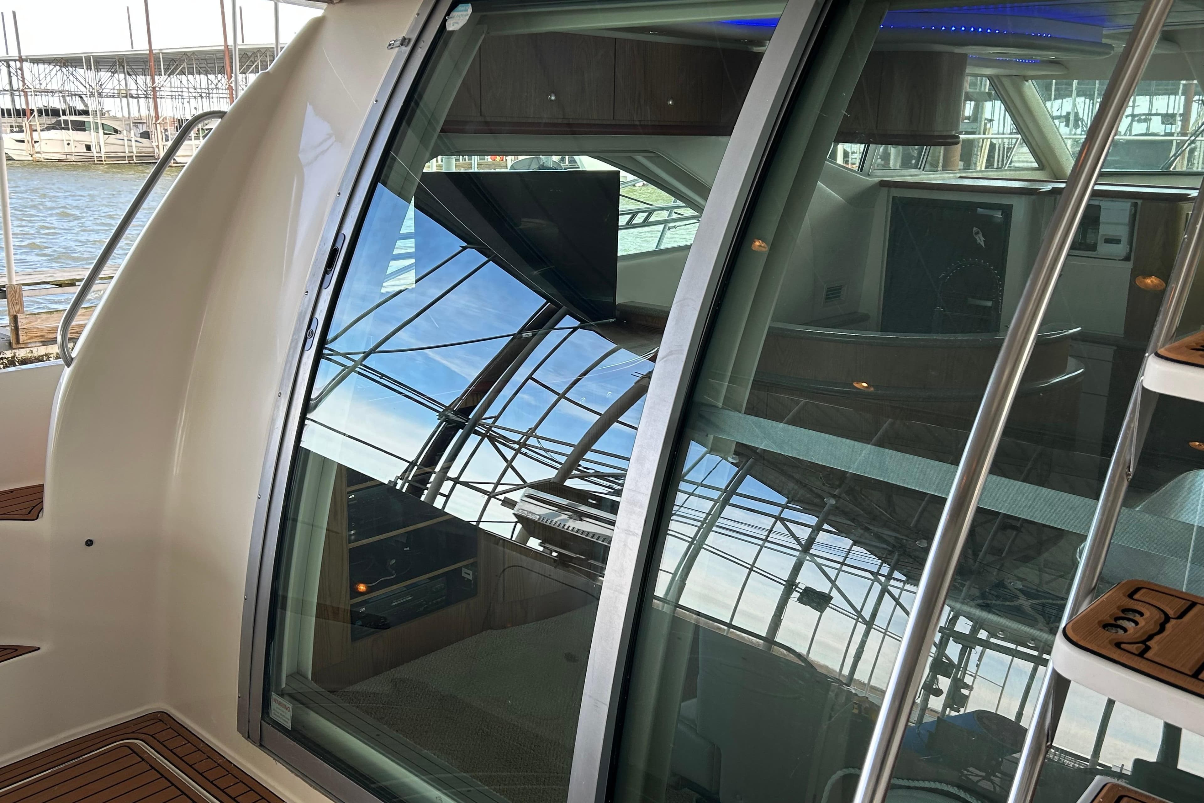 1999 Maxum 4600 SCB yacht with reflective glass doors and interior view.