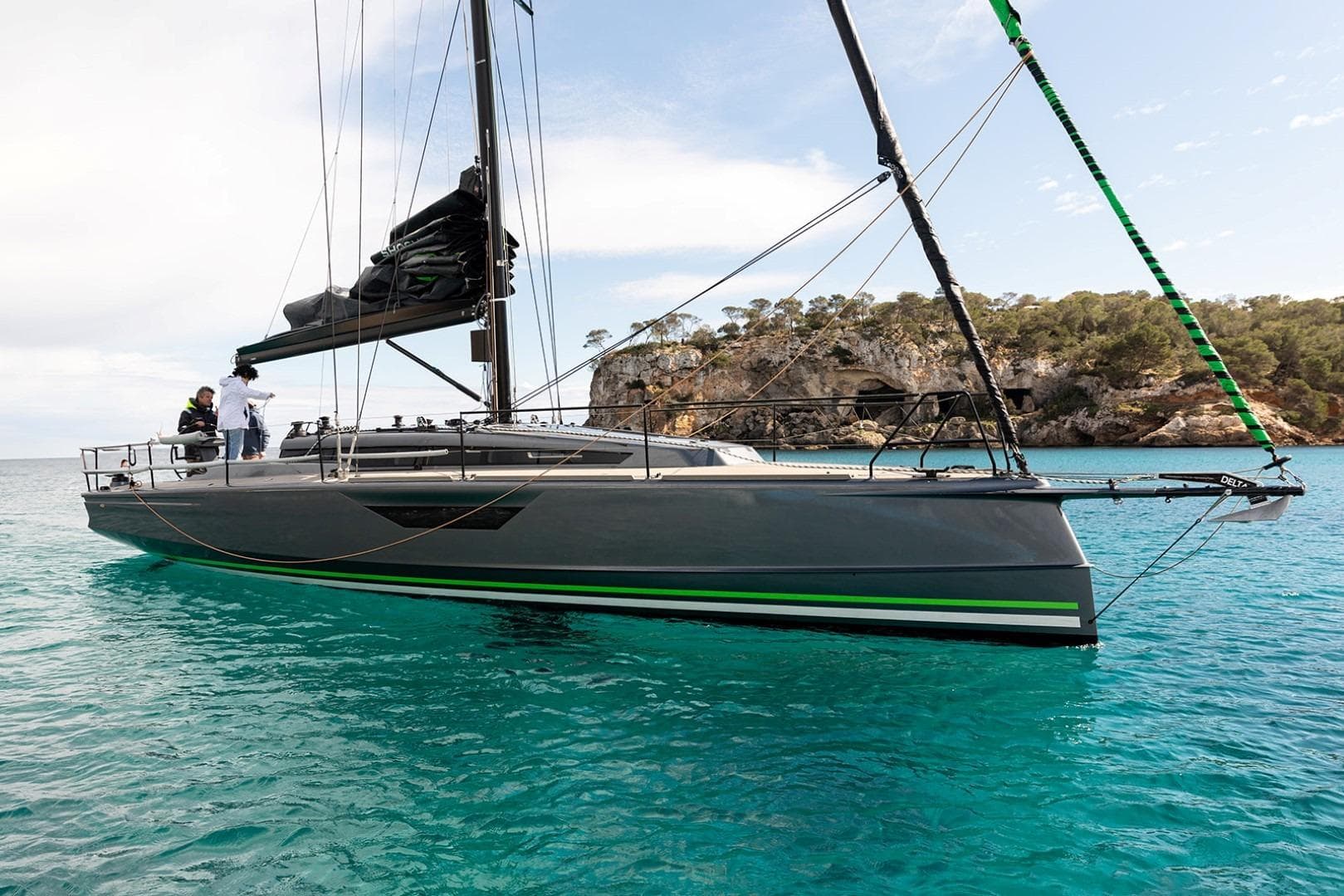 2023 Shogun 43 sailboat on turquoise water near rocky coastline.