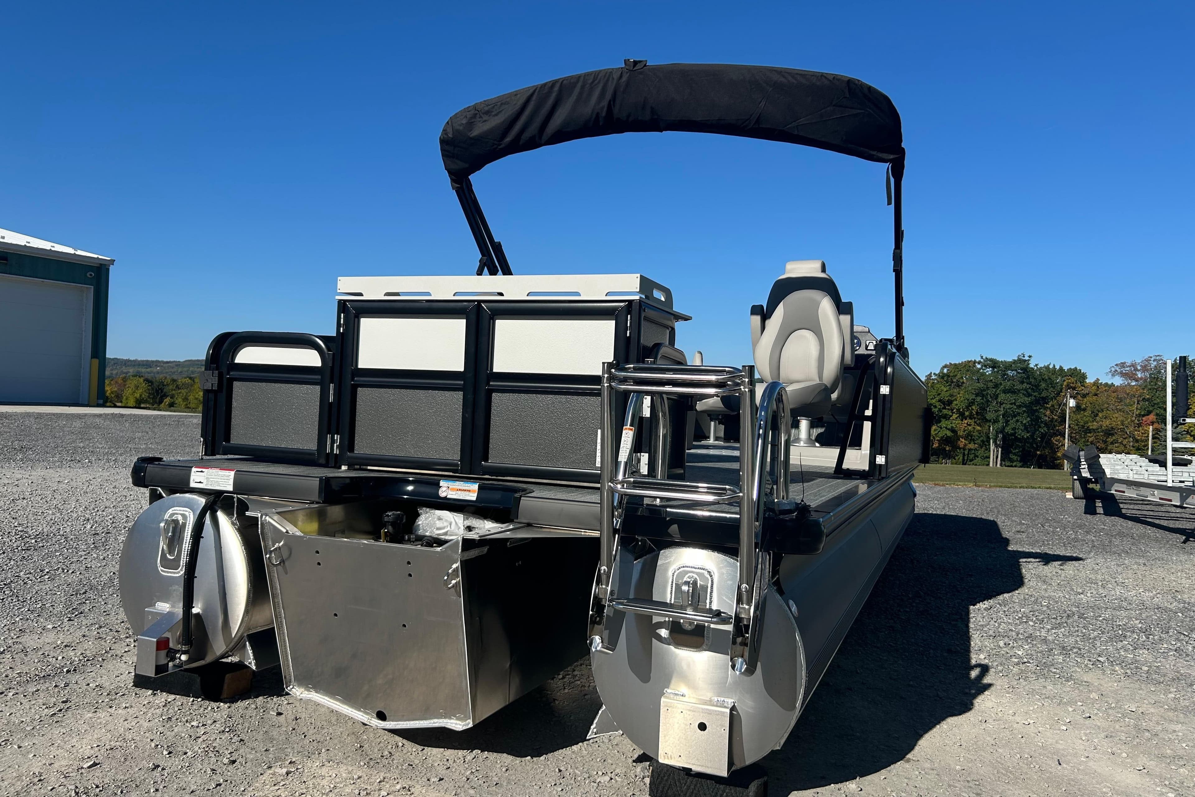 2026 Premier 230 Sunsation Angler 4pt pontoon boat with canopy, parked outdoors.