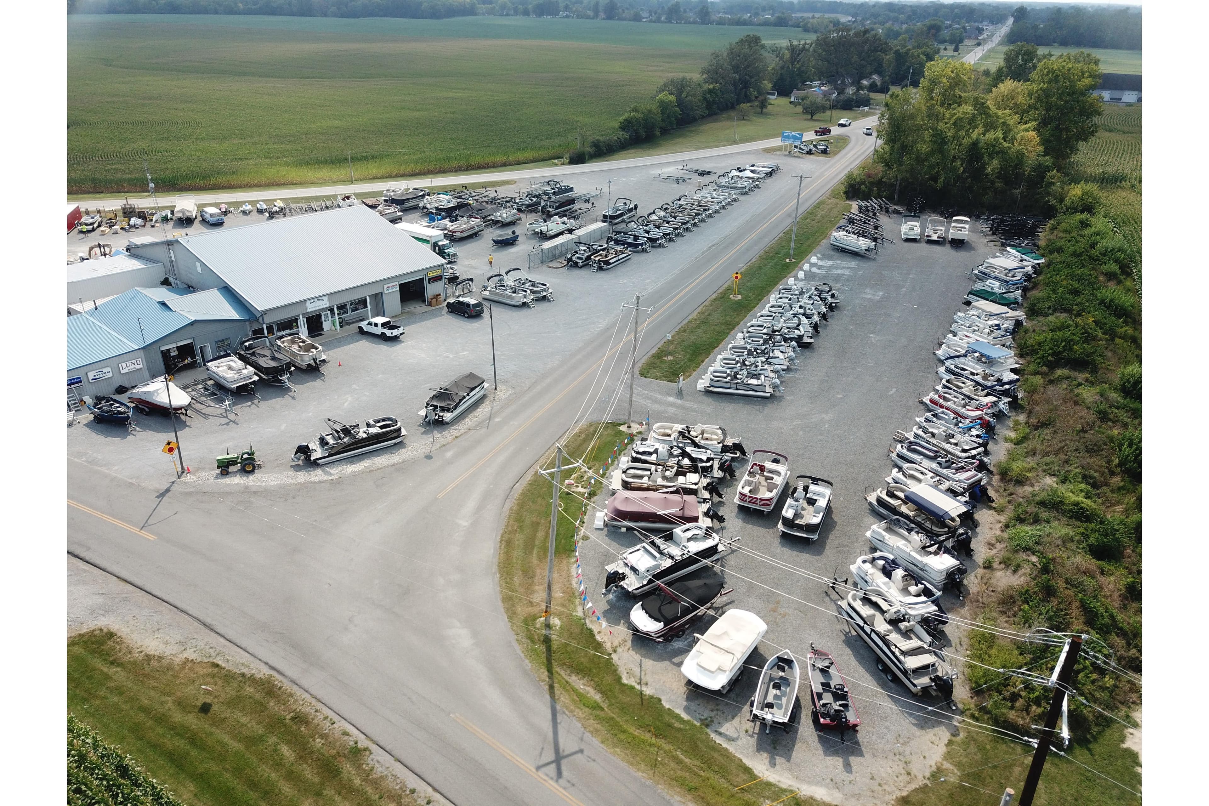 Aerial view of boat dealership showcasing Barletta ARIA 22QC, 2025 model, with various boats displayed.