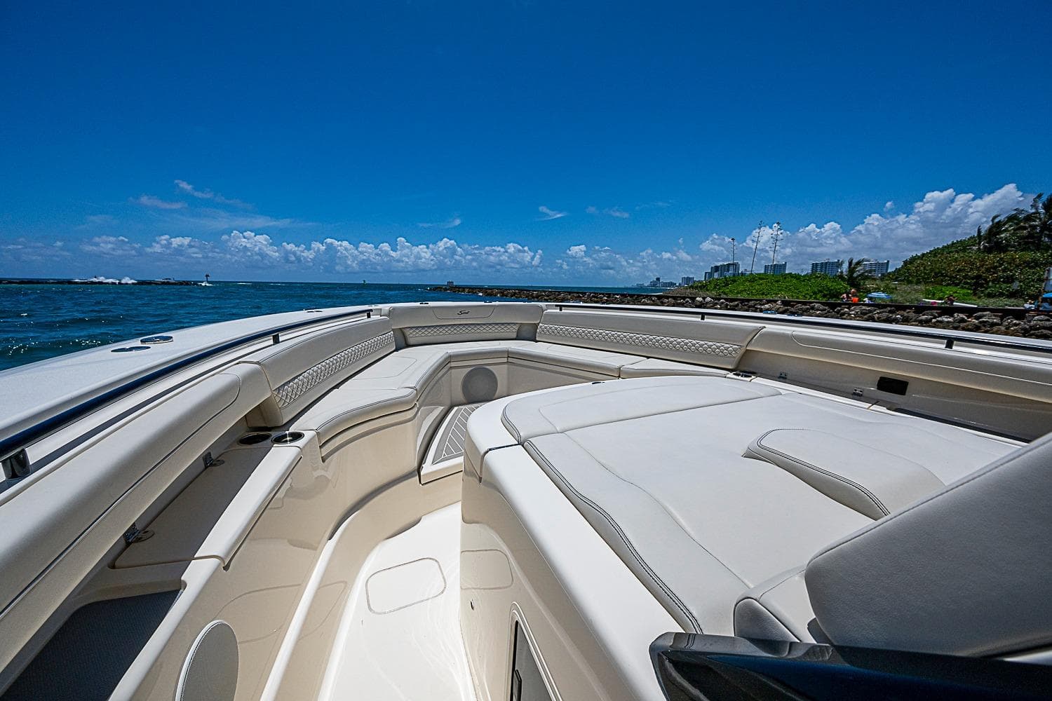 2025 Scout 425 LXF boat interior with luxurious seating, ocean view, and clear blue sky.