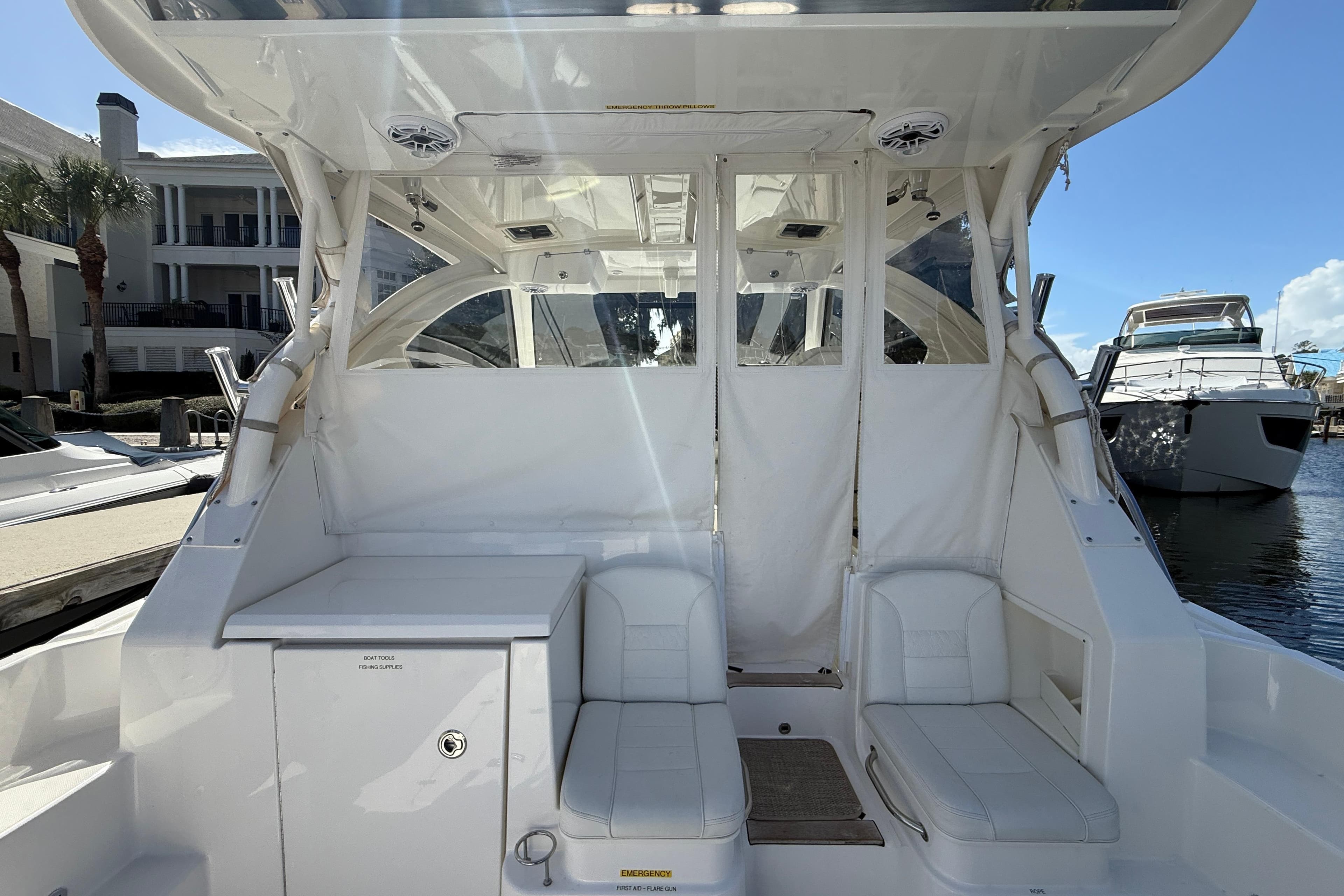 2023 Pursuit OS 355 Offshore boat interior with white seating and storage, docked at marina.