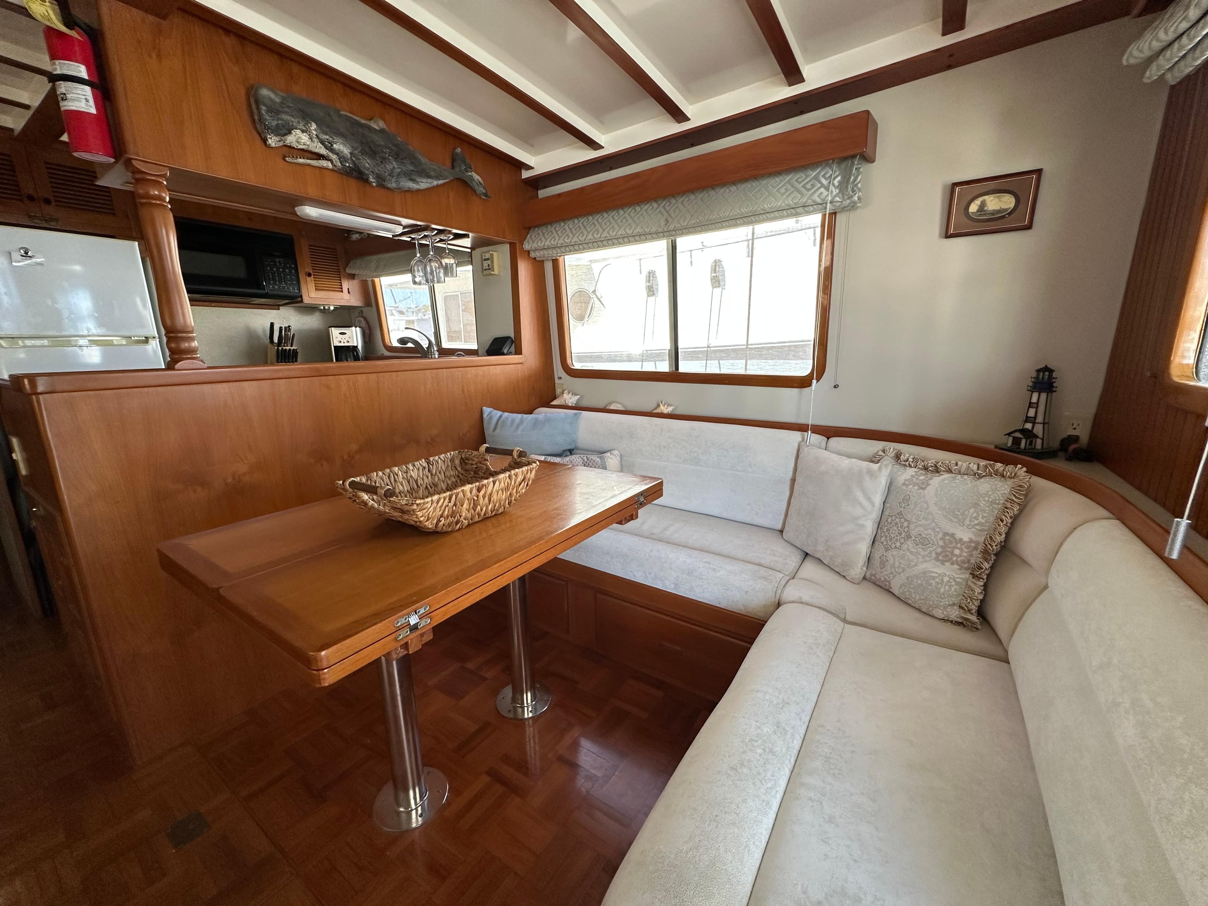 Interior of 1997 Kadey-Krogen 48 Whaleback yacht with cozy dining area and wooden accents.