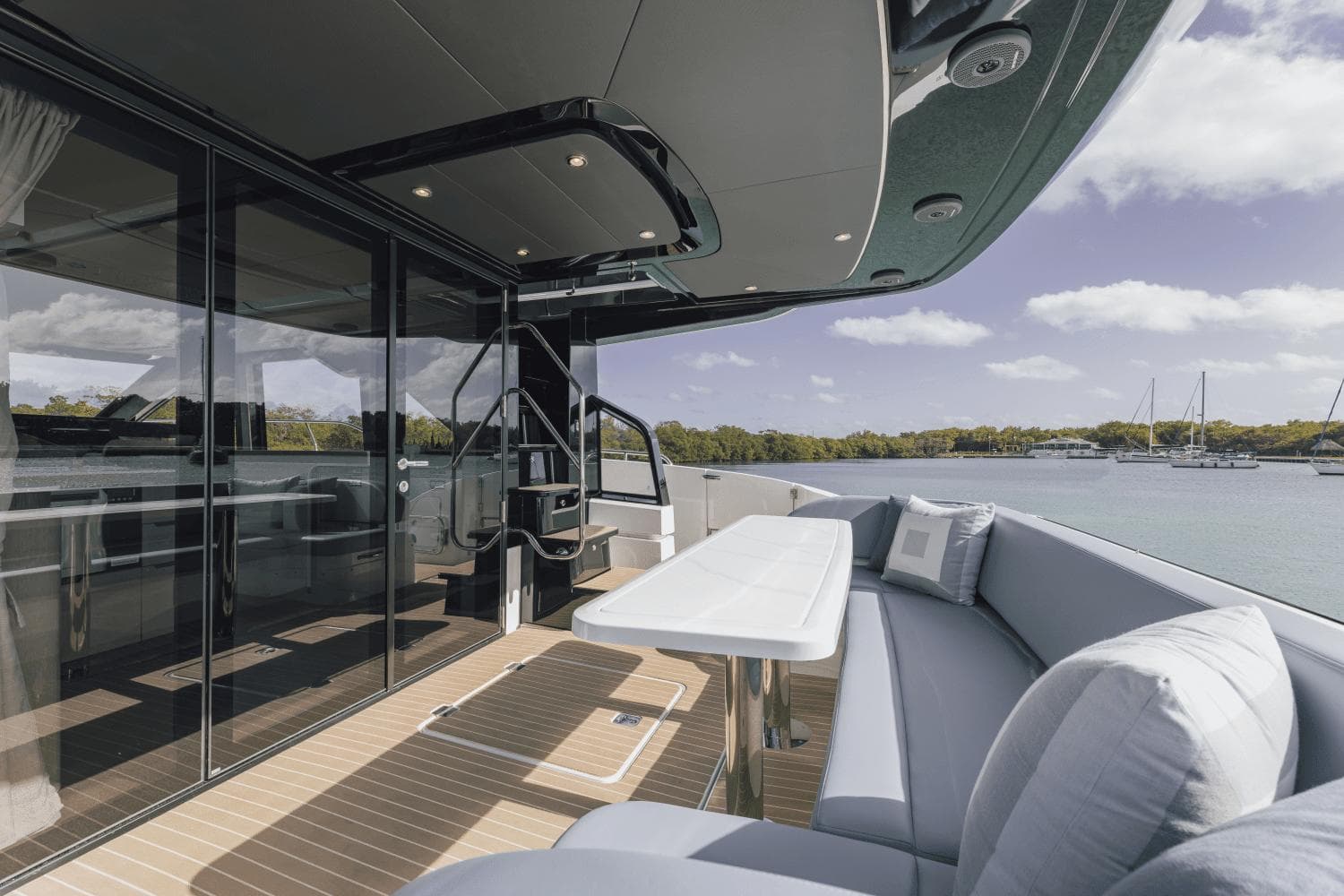 Luxurious 2025 Cruisers Yachts 57 Fly deck with elegant seating and scenic water view.