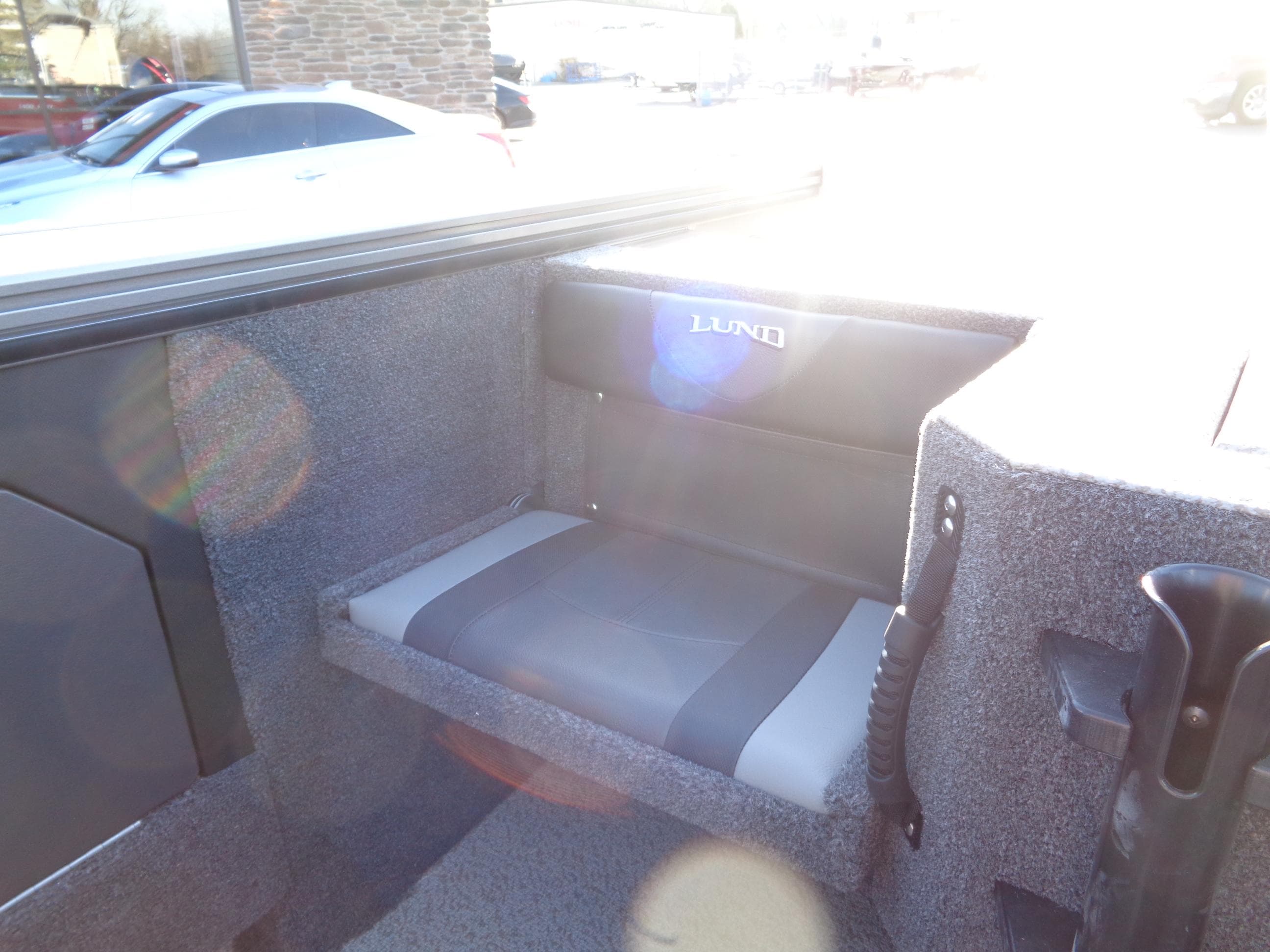 2024 Lund 1875 Fisherman boat interior with cushioned seating and carpeted flooring.