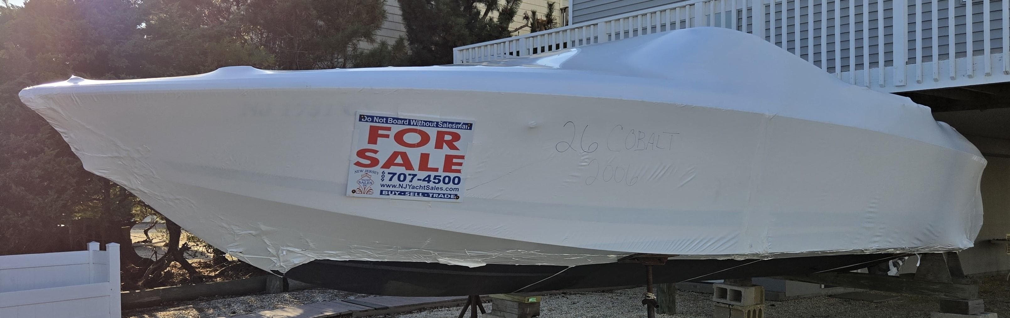 2006 Cobalt 262 boat covered and for sale, contact number visible.