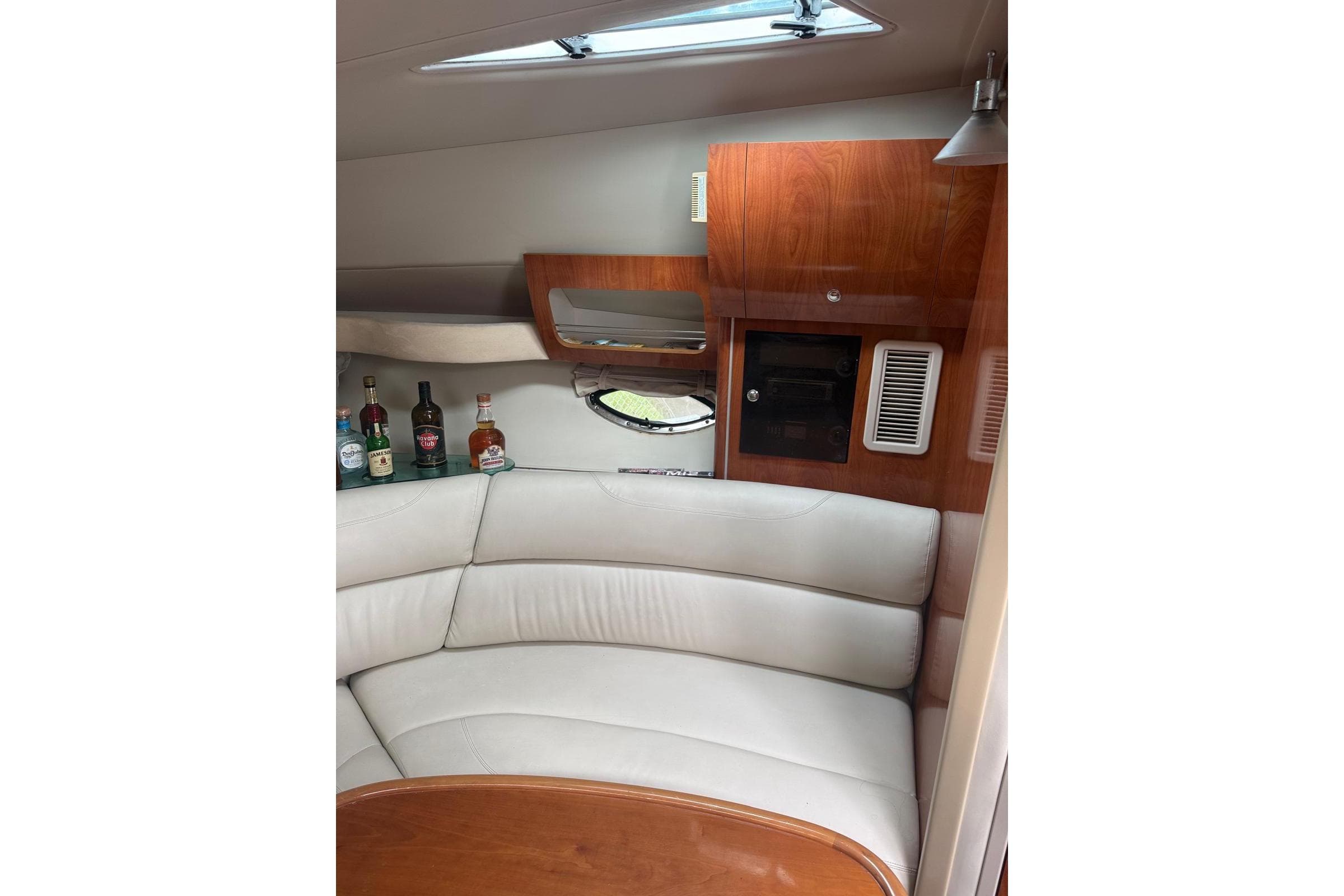 Luxurious interior of 2007 Doral Intrigue yacht with leather seating and wooden cabinetry.