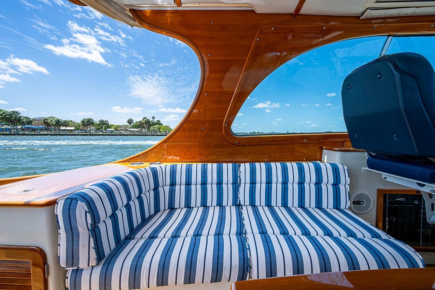 Interior of 2013 Hinckley Picnic Boat 37 MKIII with striped seating and scenic water view.