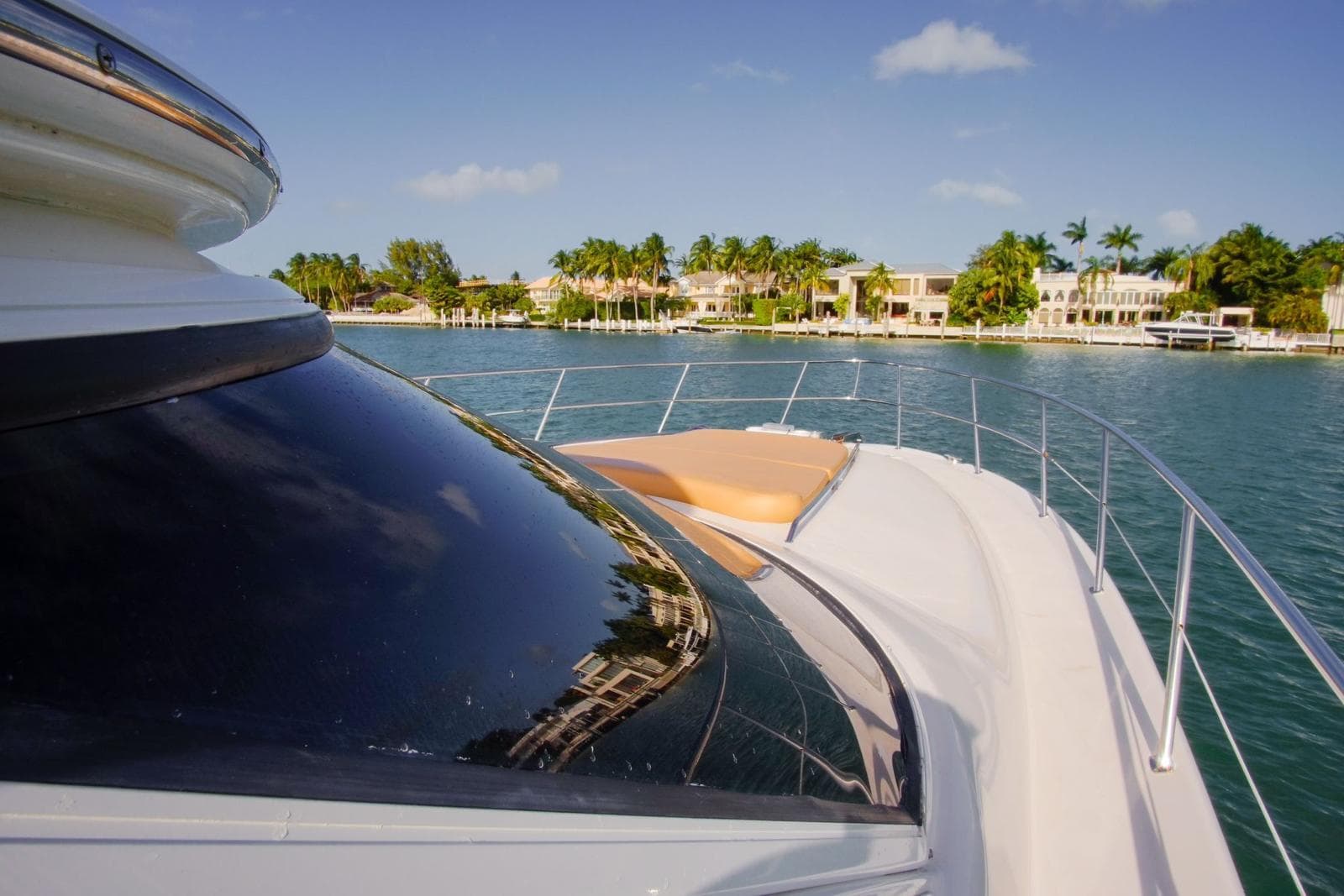 2001 Sea Ray 480 Sedan Bridge yacht cruising near waterfront homes.