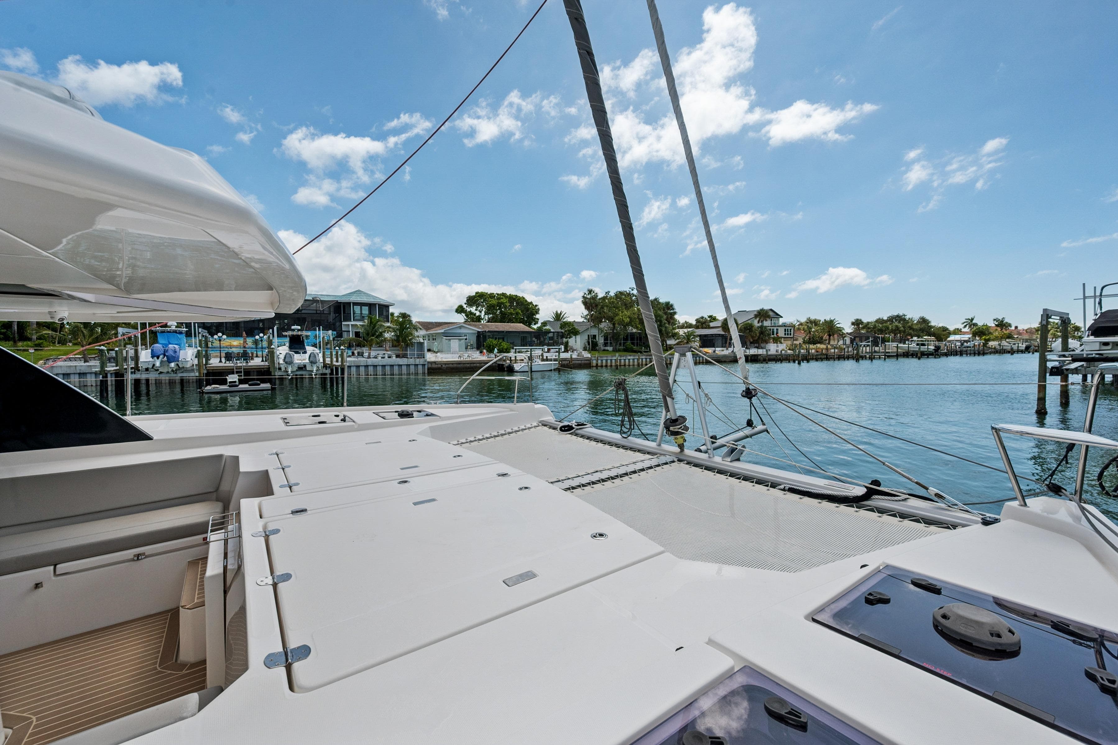 2021 Leopard 45 catamaran deck with scenic waterfront view and clear blue sky.