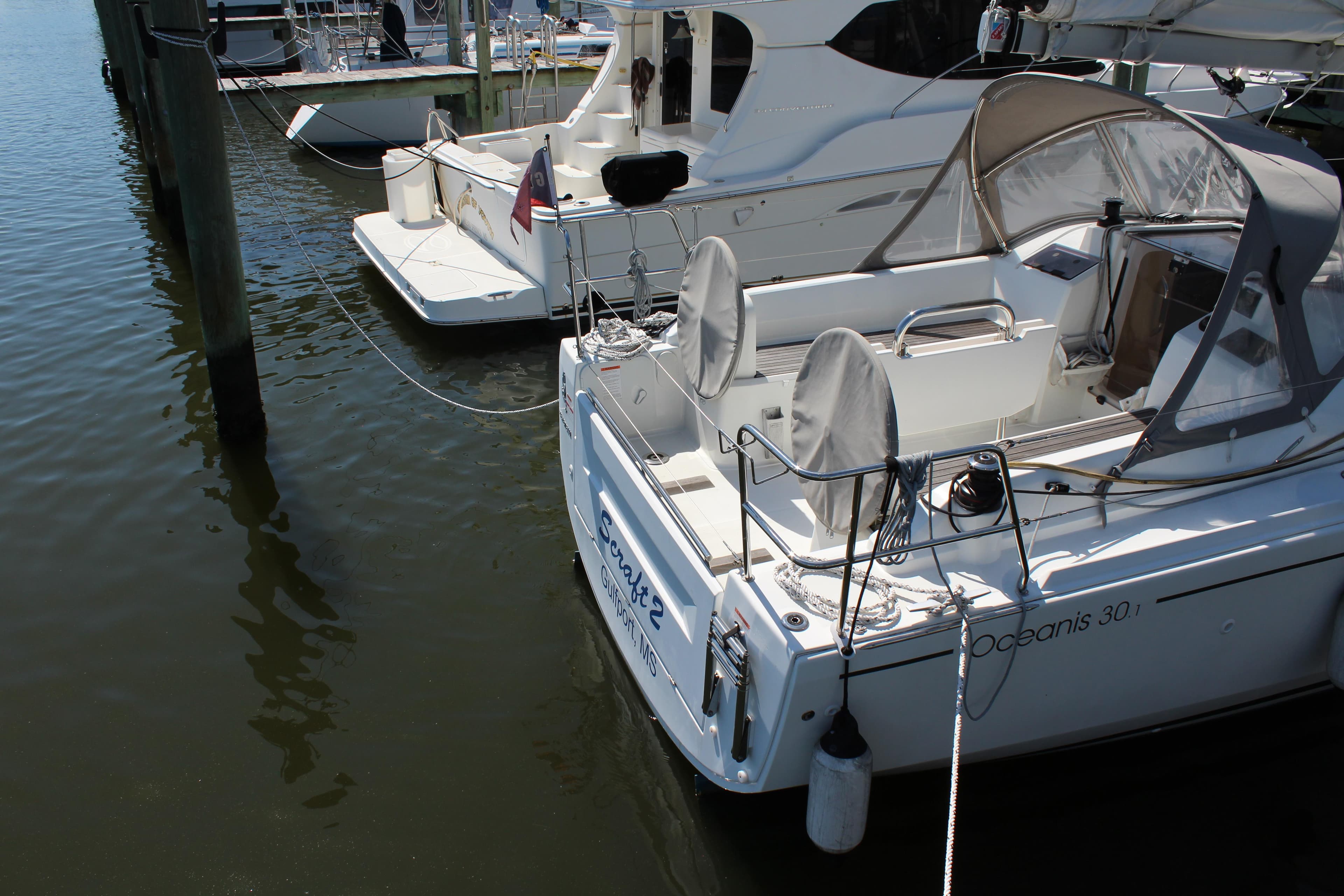 Beneteau Oceanis 30.1 sailboat docked, 2022 model, with covered seating and nautical equipment.
