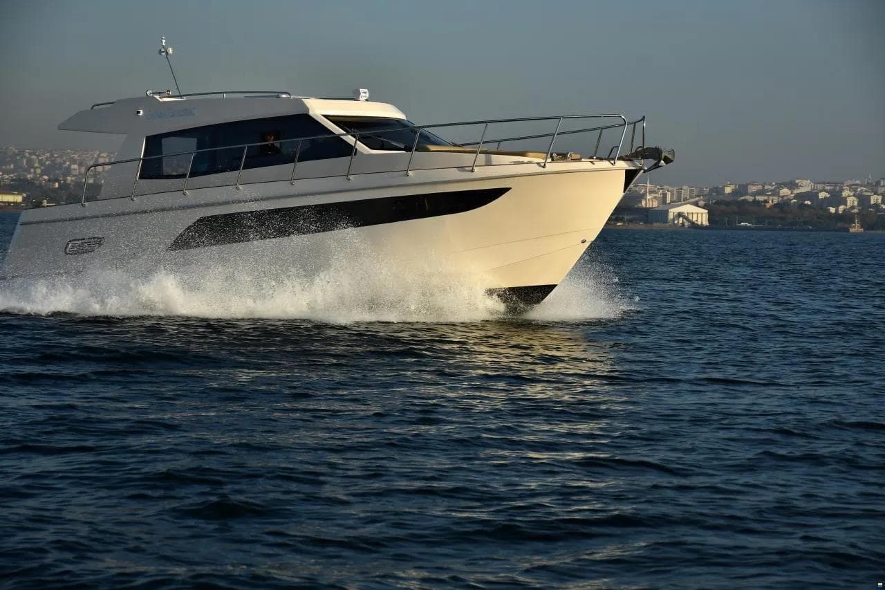 Erman Yachting Comfort 36 cruising on open water, cityscape in background.