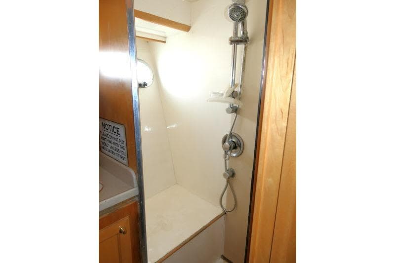 Shower area in 1999 Hampton 490 Pilothouse yacht, featuring modern fixtures and wooden accents.