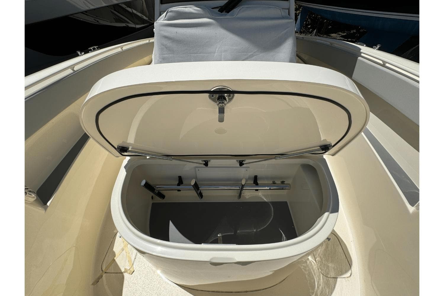 Open storage compartment on 2024 Scout 357LXF boat, showcasing interior features.