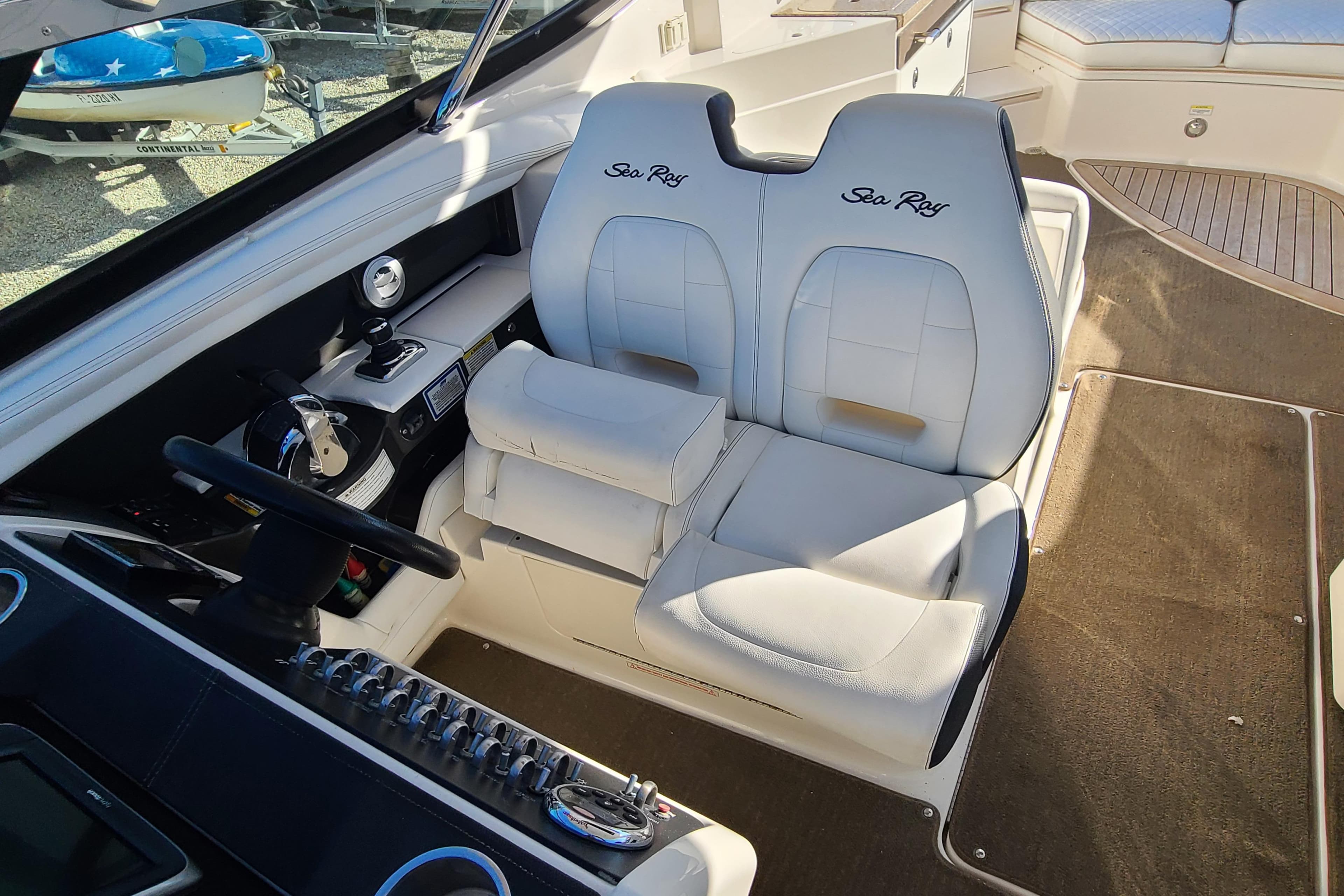Interior of 2014 Sea Ray 350 SLX boat with white leather seats and control panel.