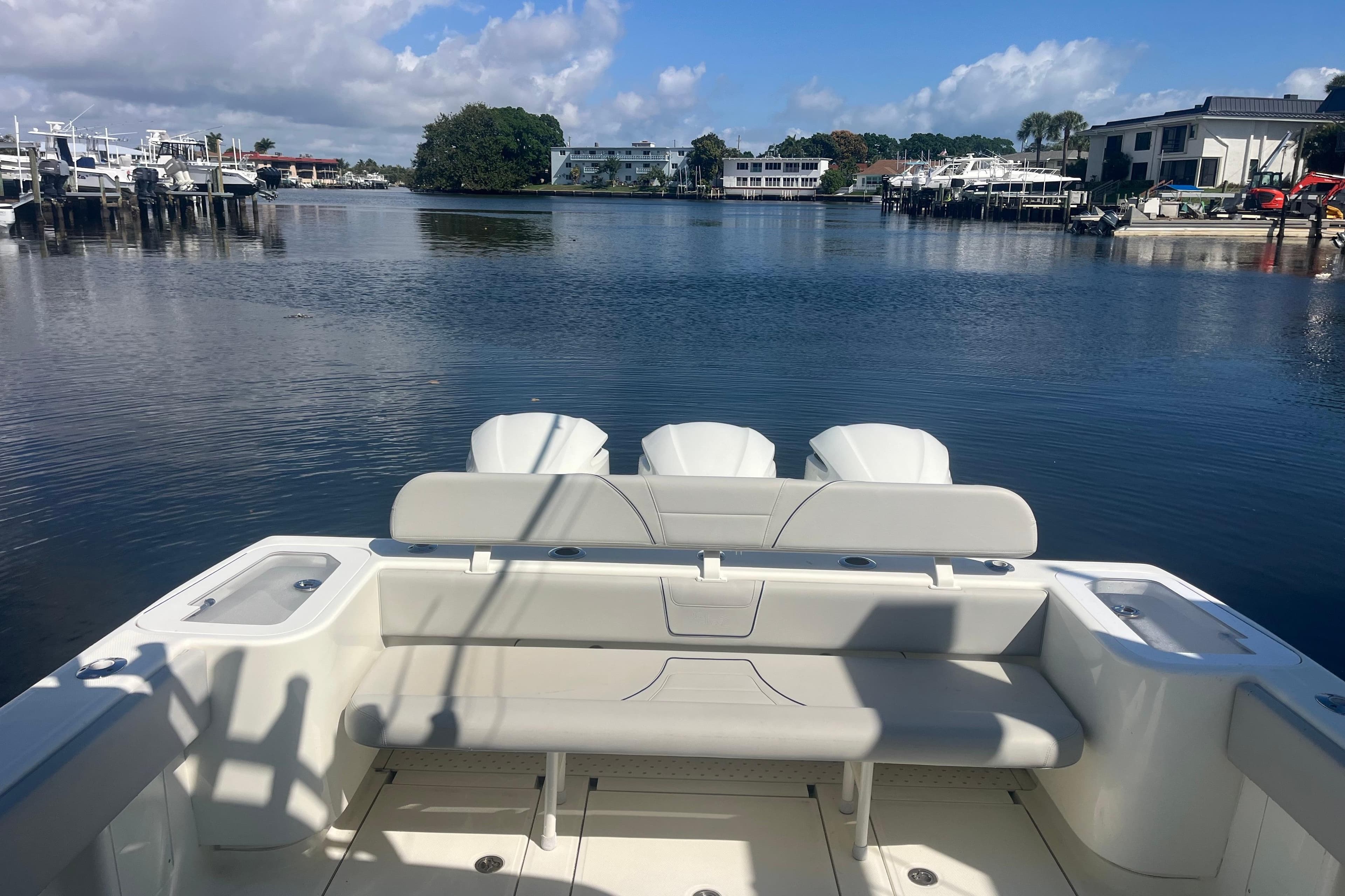 2017 SeaVee 370Z boat with triple engines docked in a serene marina setting.