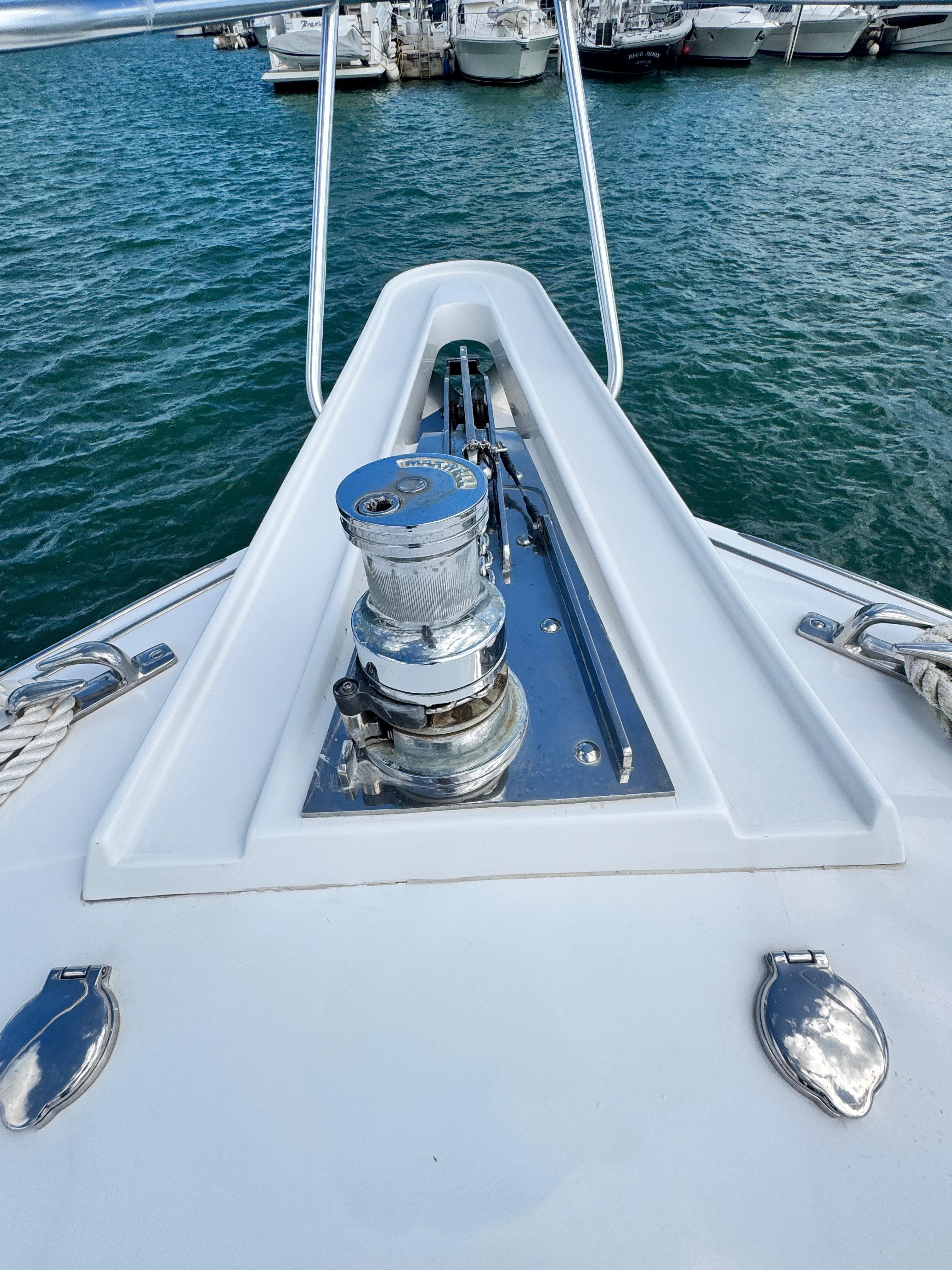2011 Hatteras GT60 yacht bow with anchor winch, docked in marina.