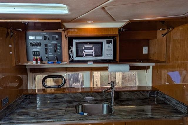 2013 Sea Ray 470 Sundancer kitchen with microwave, sink, and control panel.