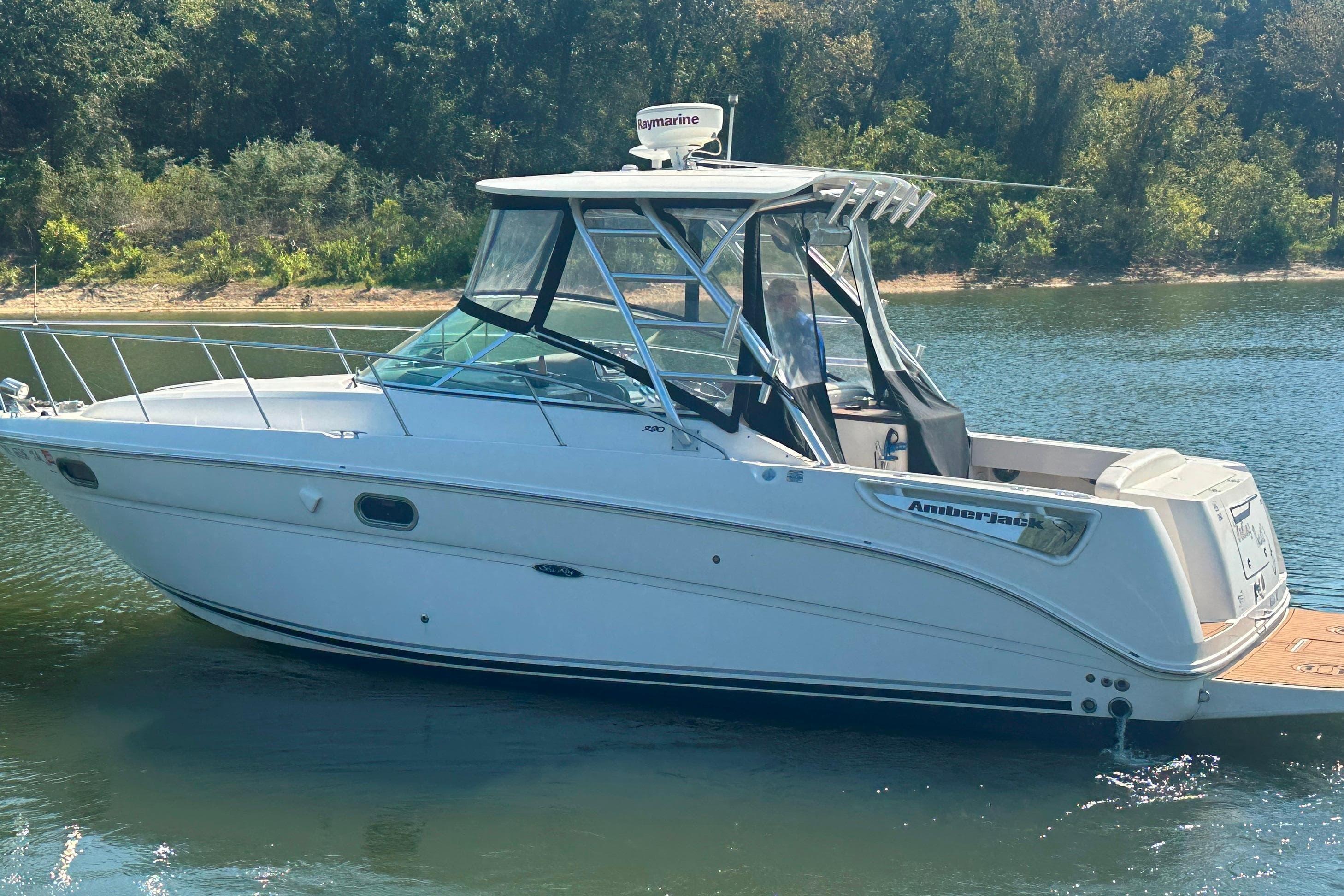 2008 Sea Ray 290 Amberjack boat on calm water, surrounded by lush greenery.