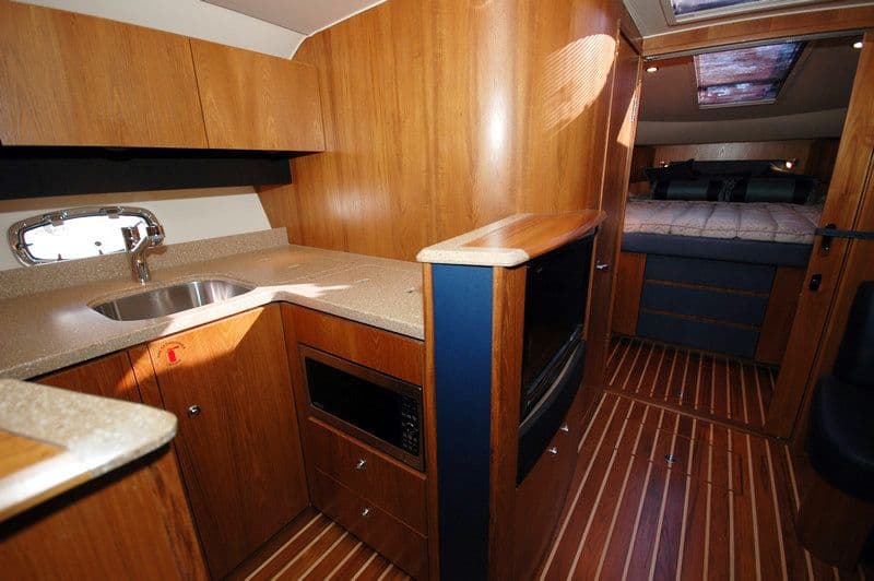 Interior of 2012 Tiara Yachts 3900 Open with kitchen and sleeping area.