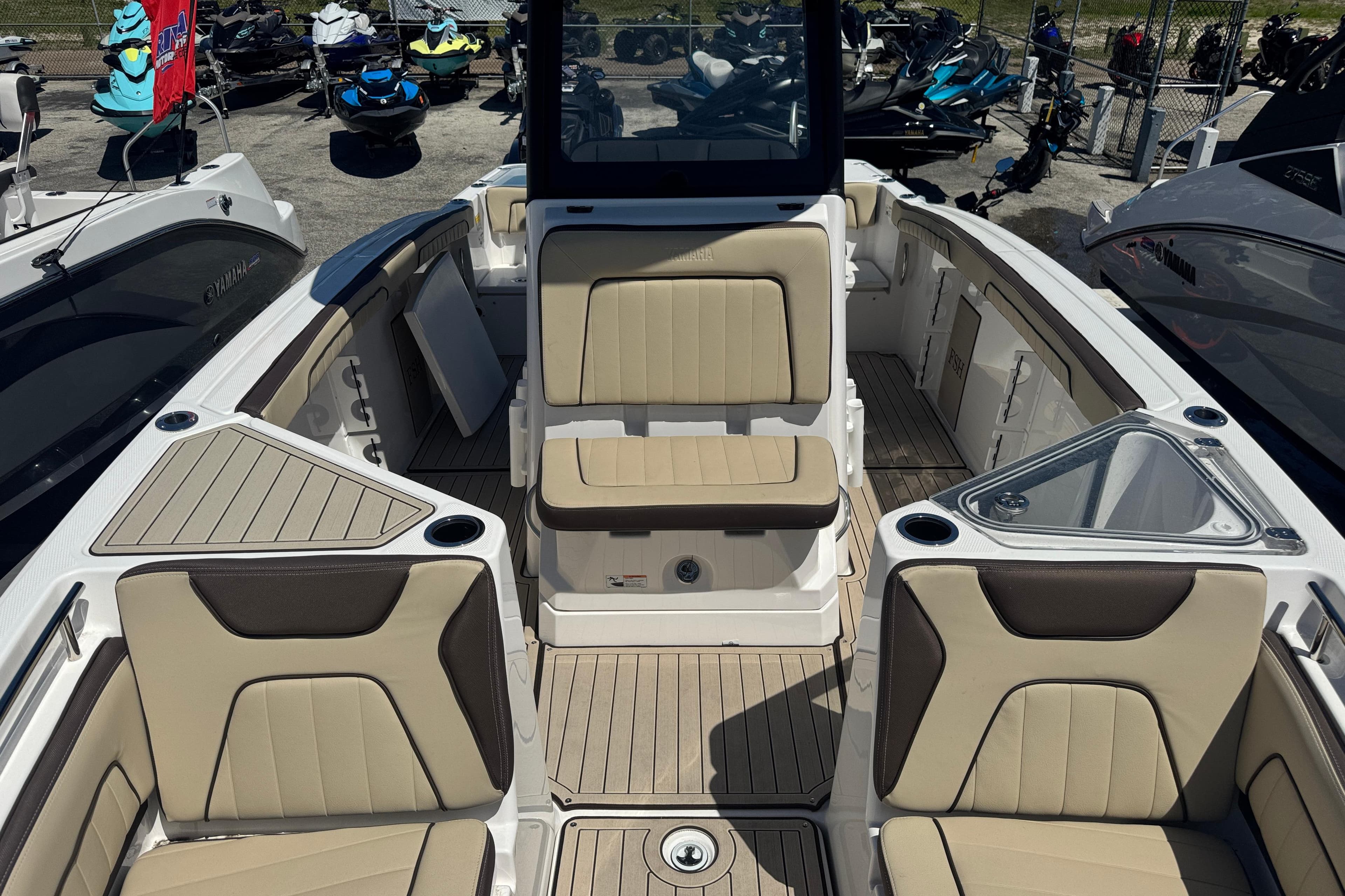 2026 Yamaha Boats 255 FSH Sport E interior with beige seating and modern design.
