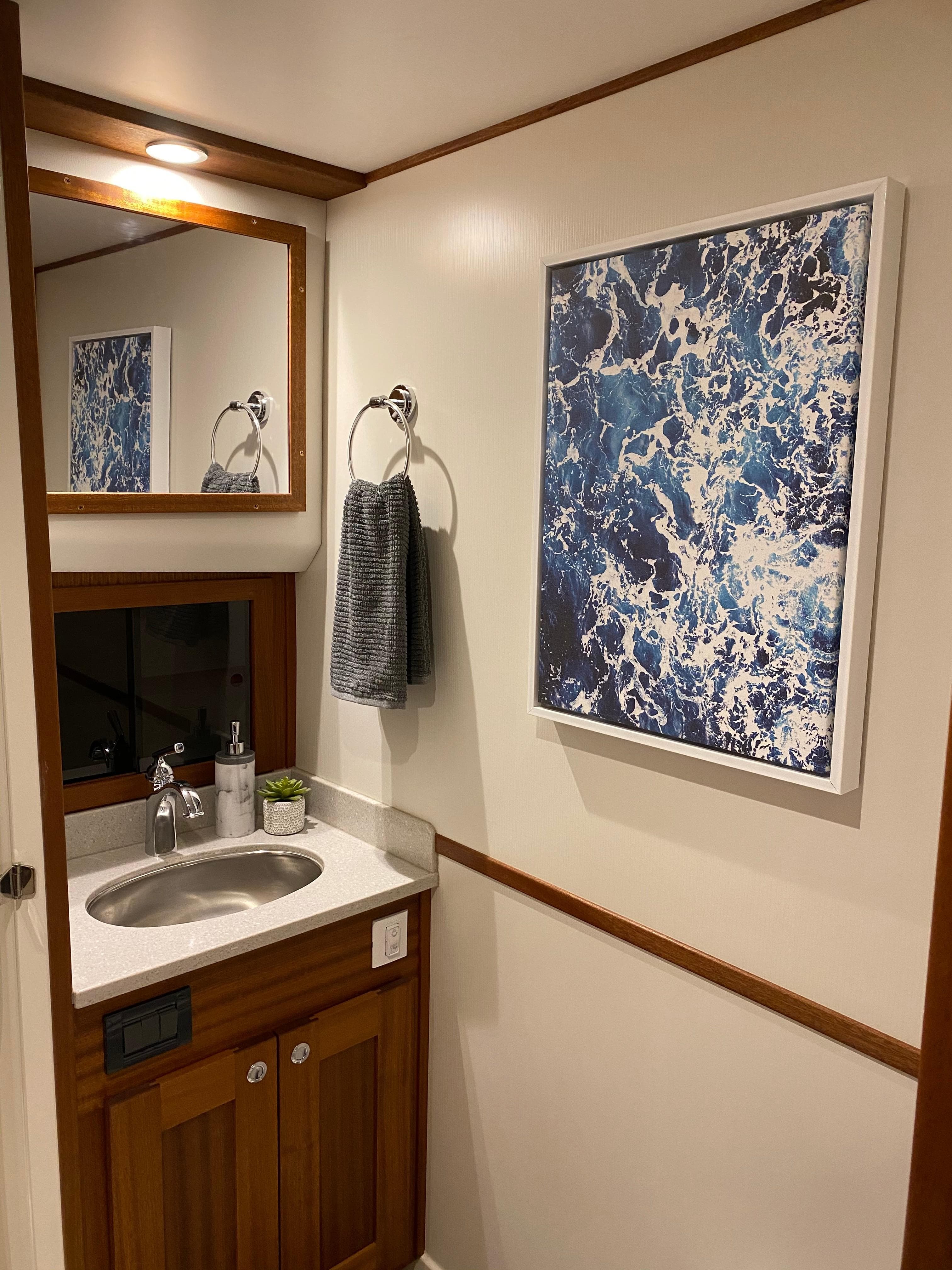 Modern bathroom in 2025 American Tug 362 with ocean-themed artwork.