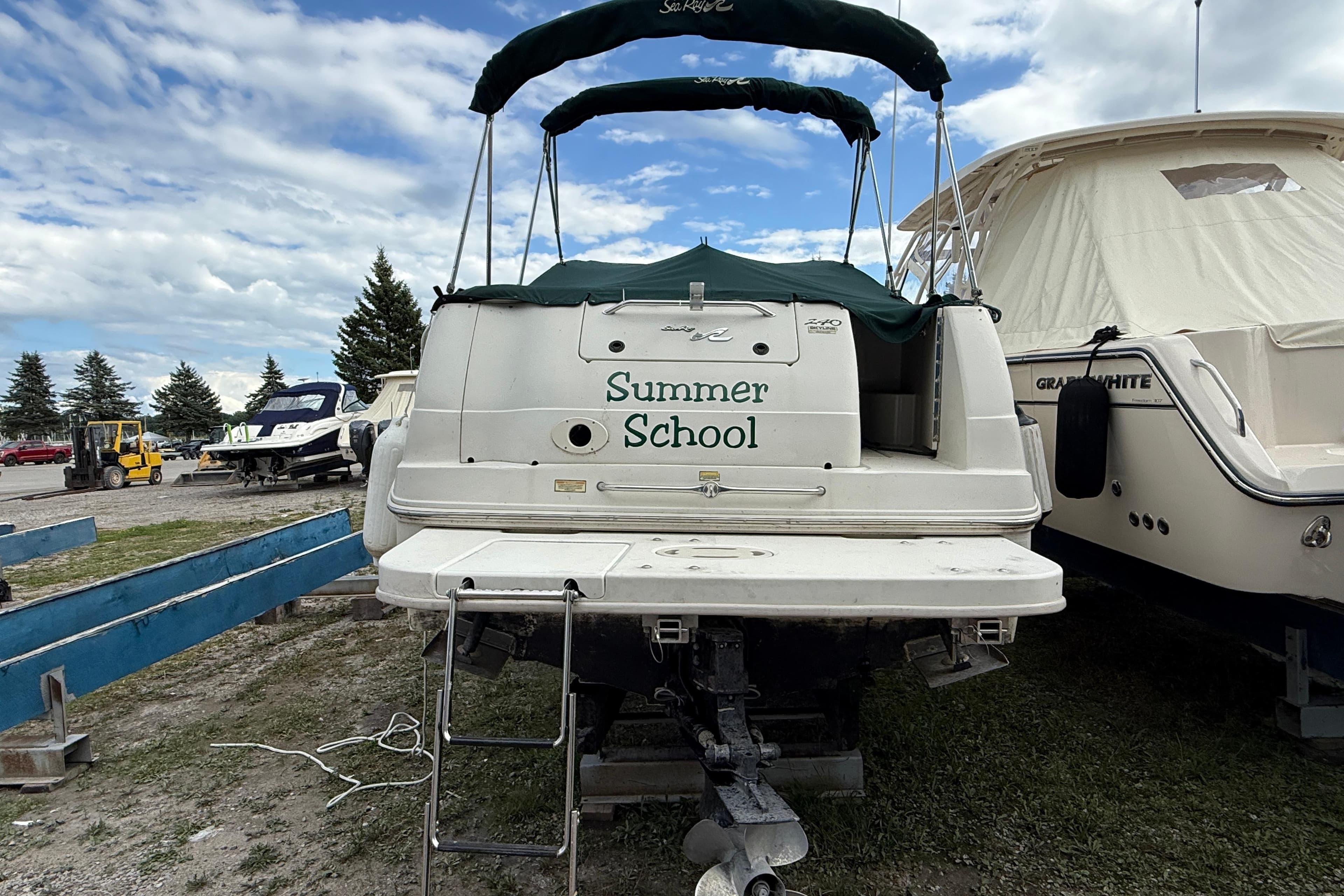 2000 Sea Ray 240 Sundancer boat named "Summer School" docked outdoors.
