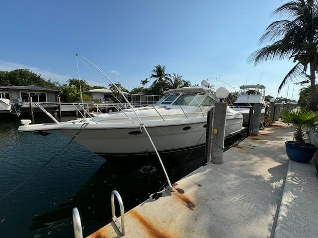1996 Tiara Yachts 3500 Express docked at a marina with palm trees.