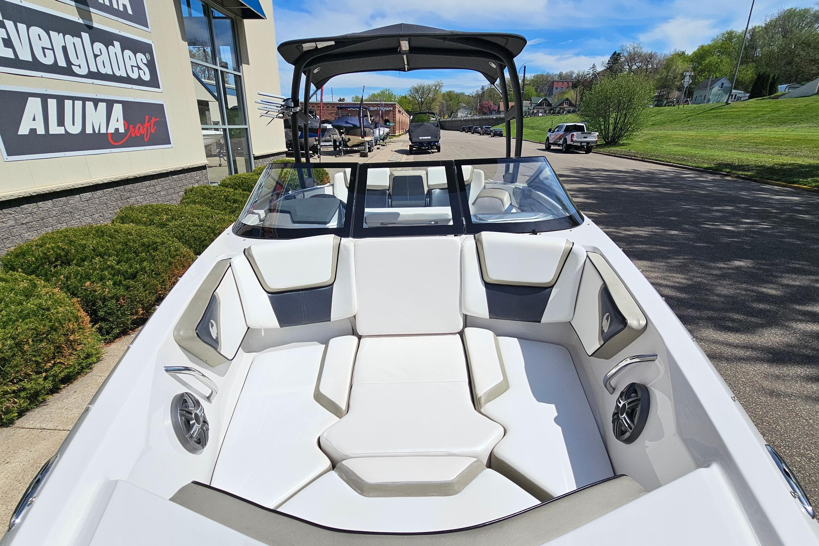 2014 Scarab 215 boat with white seating, parked outdoors near dealership.