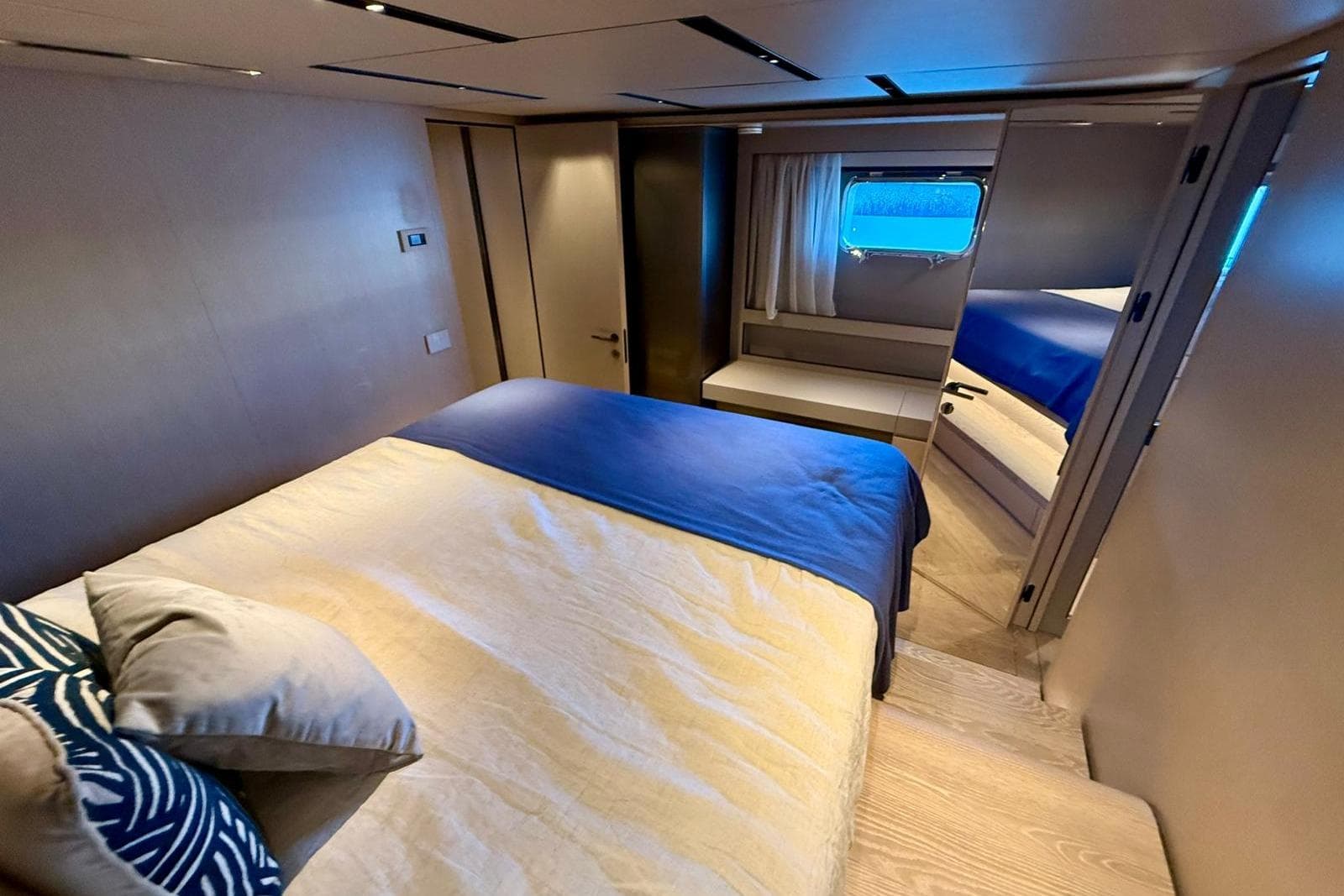 Luxurious cabin interior of 2025 Bluegame BGM75 yacht with modern design and cozy bedding.