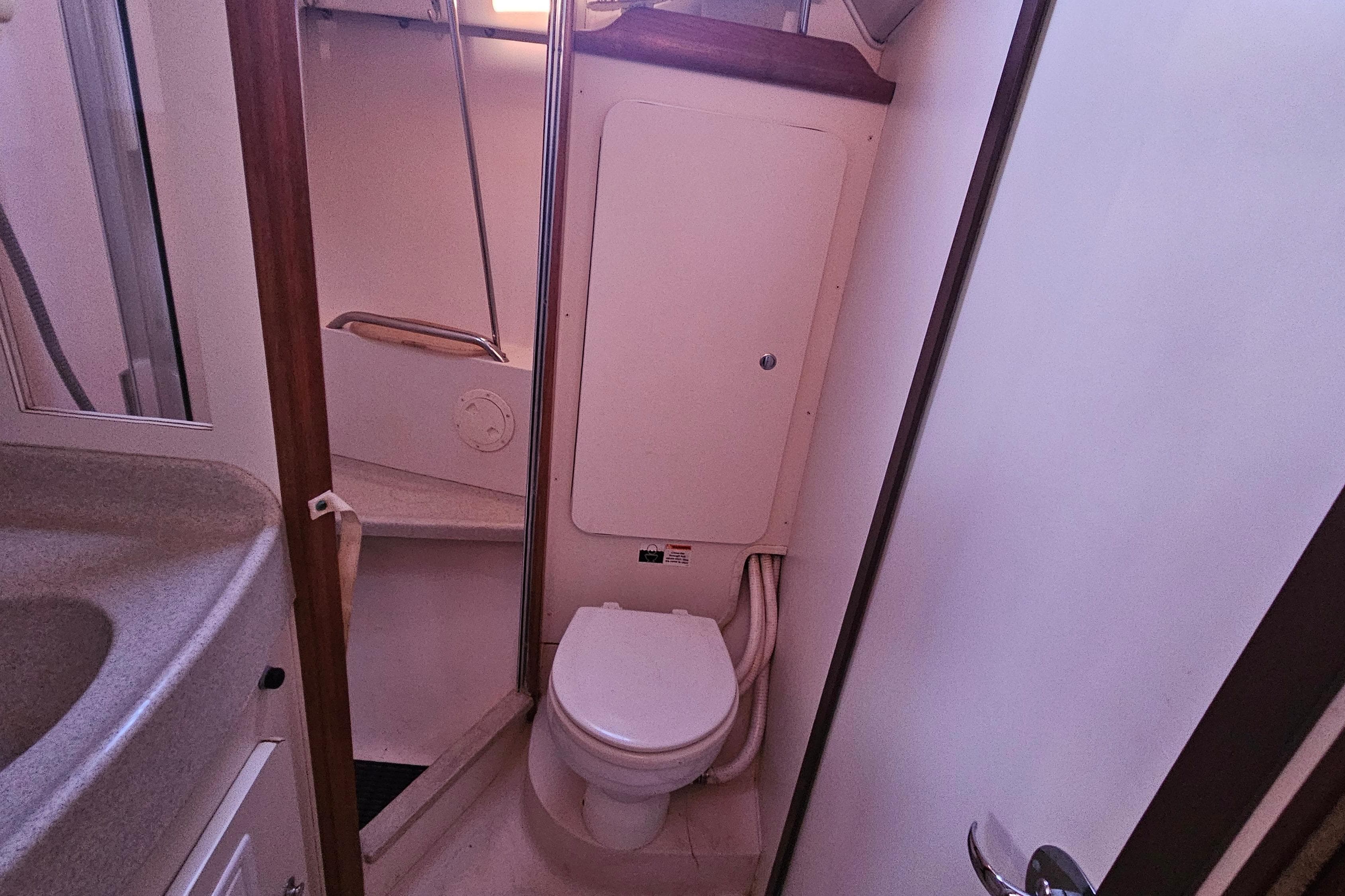 Compact bathroom interior of a 2005 Catalina 350 sailboat, featuring a toilet and sink.