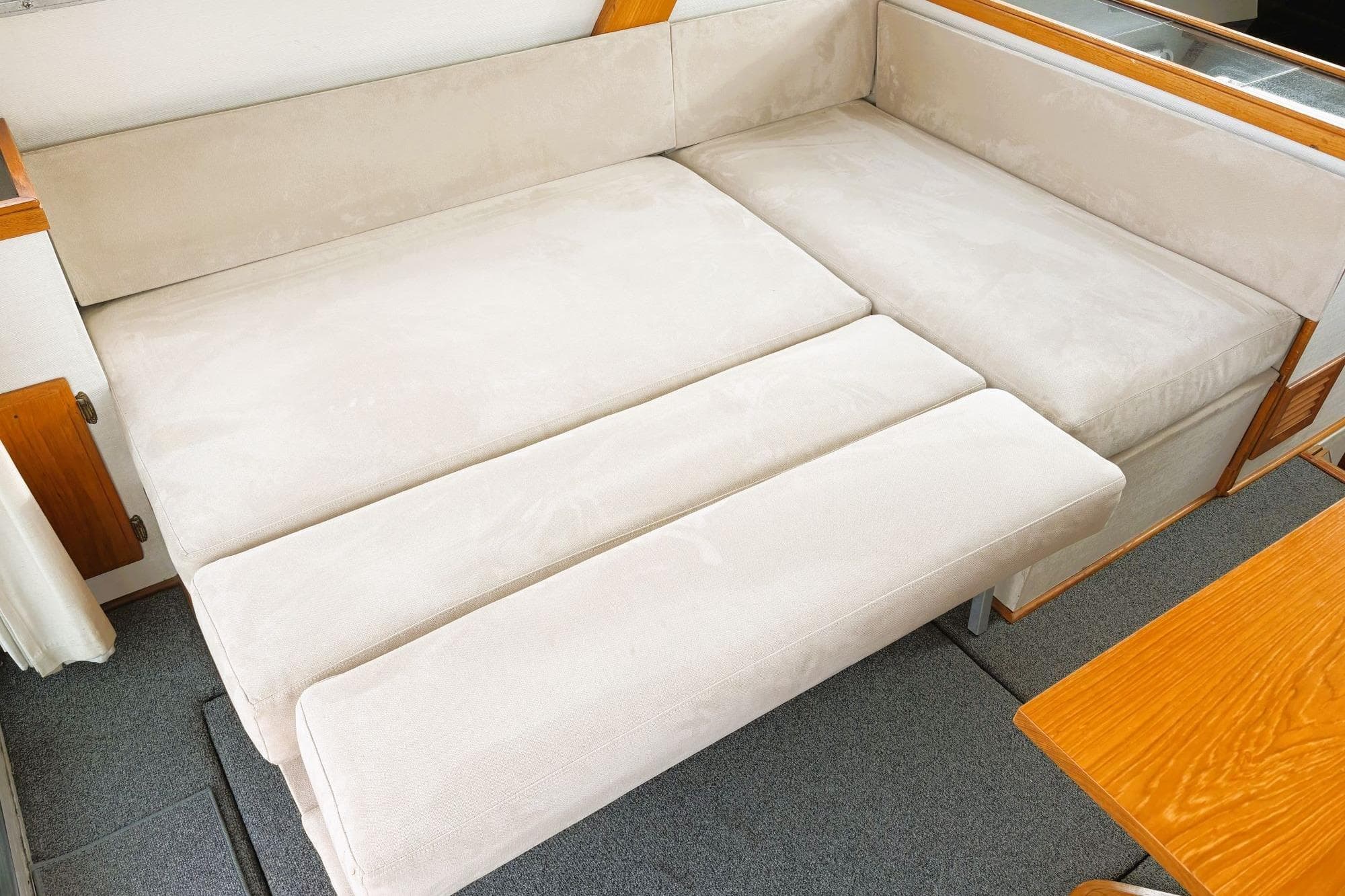 Beige sofa bed in 1980 Tollycraft 34 Sedan boat interior.