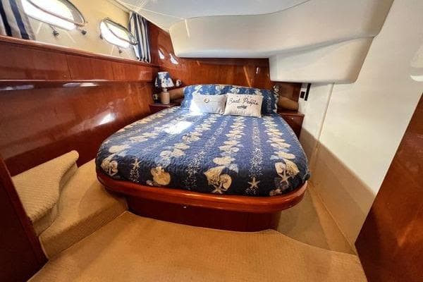Luxurious cabin interior of 2003 Viking Princess 50 Sport Cruiser with nautical-themed bedding.