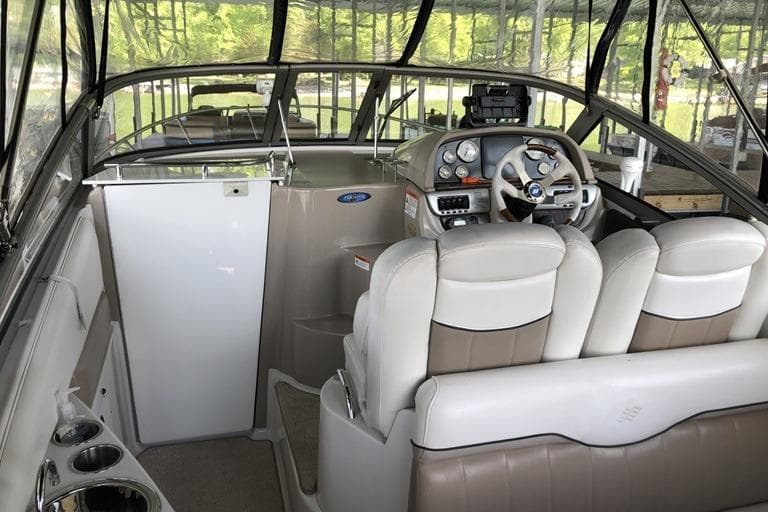 Interior of a 2006 Four Winns 258 Vista boat with steering wheel and seating.