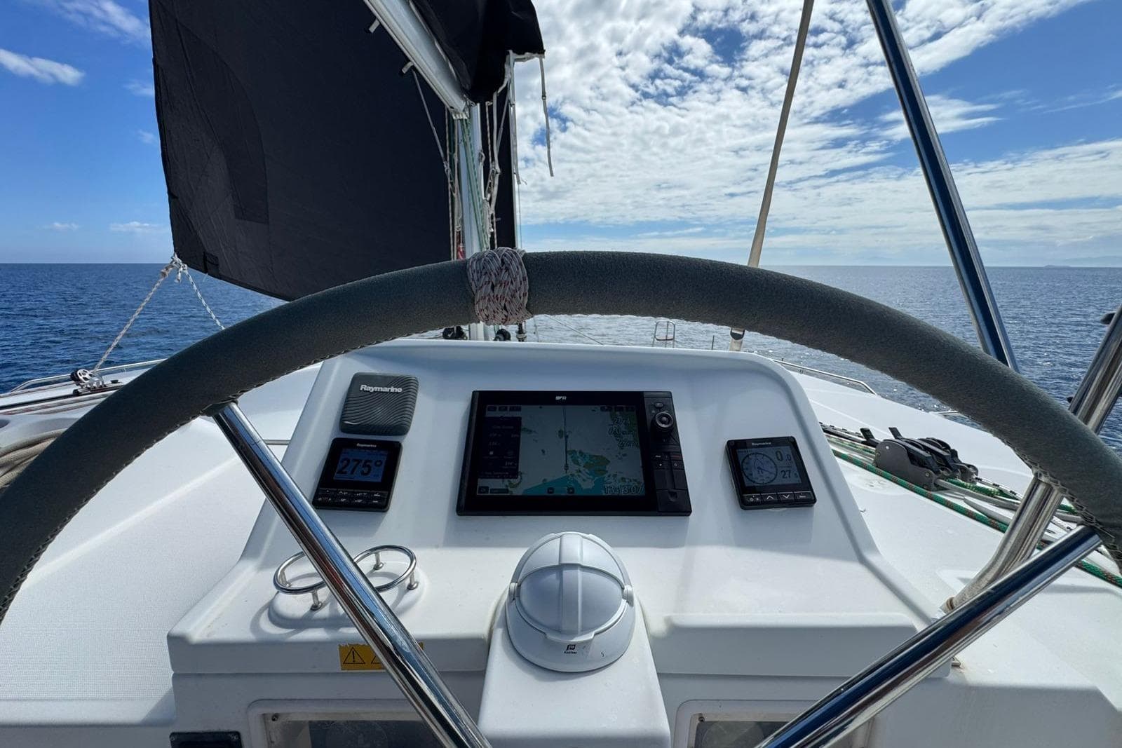Helm view of 2011 Lagoon 450 F catamaran with navigation instruments and ocean horizon.